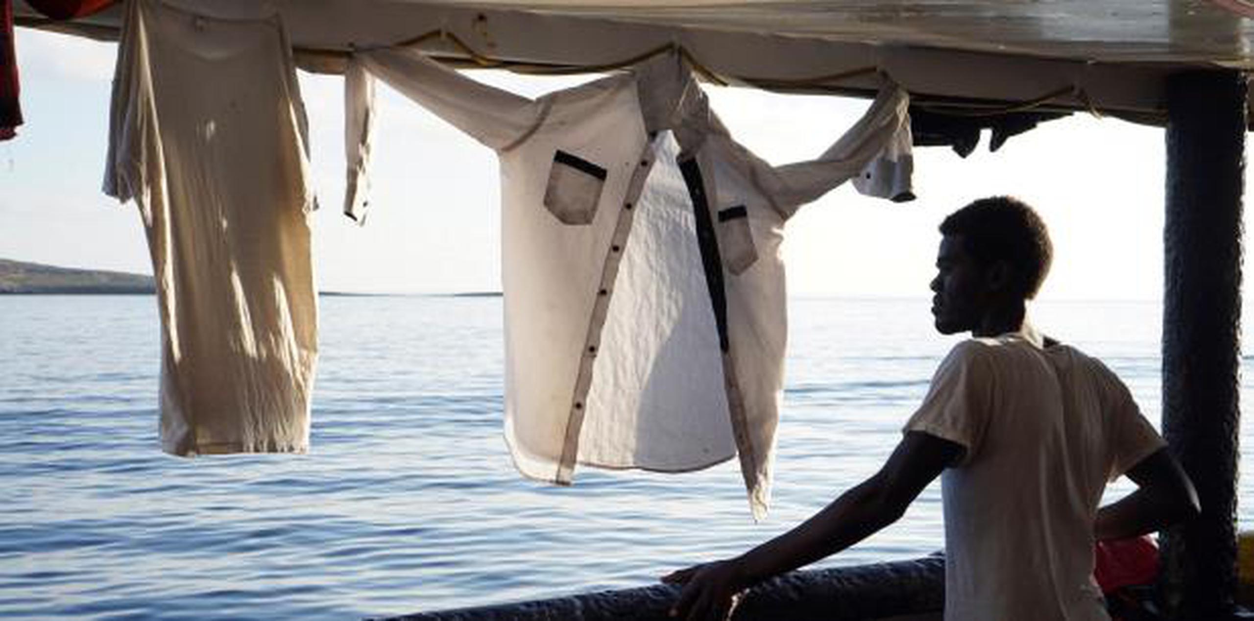Un migrante mira este domingo desde la cubierta de el buque "Open Arms" las costas de Lampedusa (Italia). (EFE)