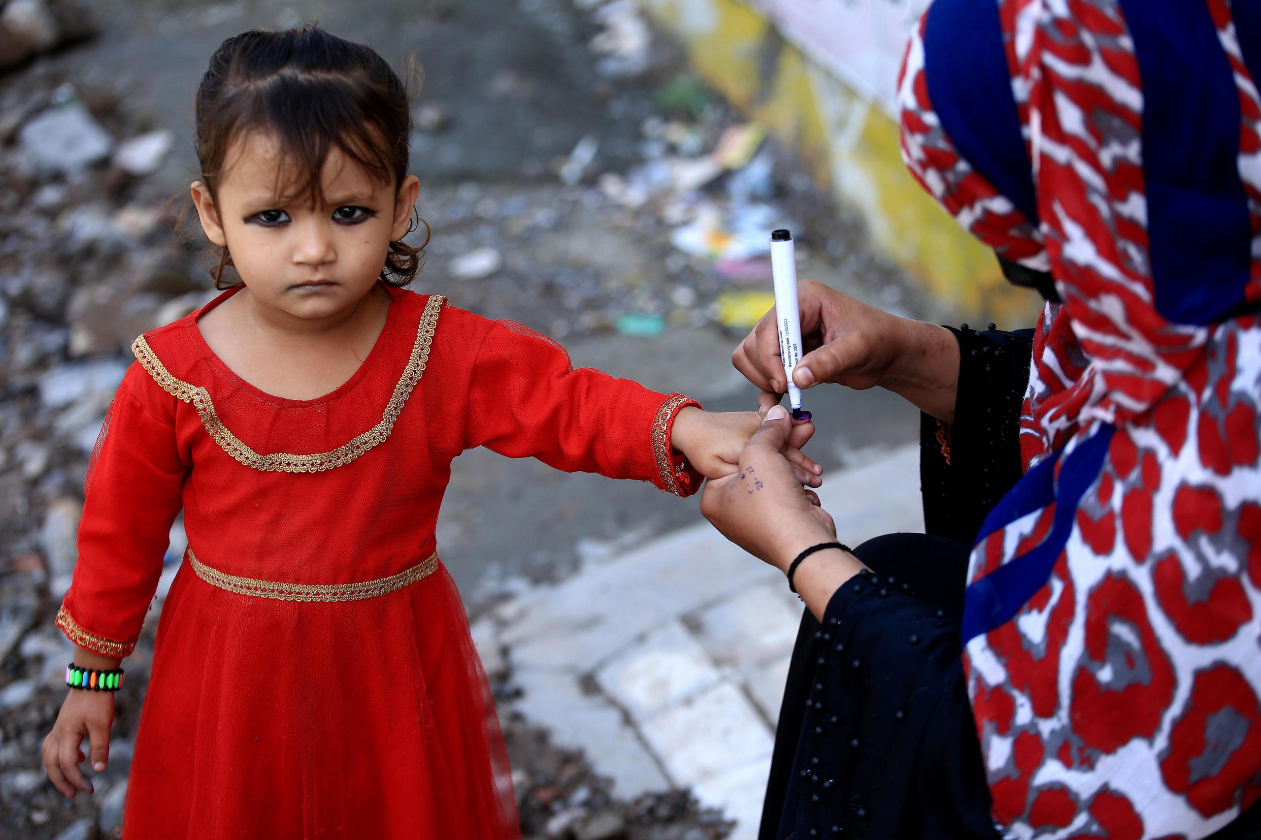 Un trabajador de la salud marca la mano de un niño después de administrarle gotas de vacuna contra la polio durante una campaña de vacunación puerta a puerta, en Peshawar, Pakistán, el 29 de abril de 2024.