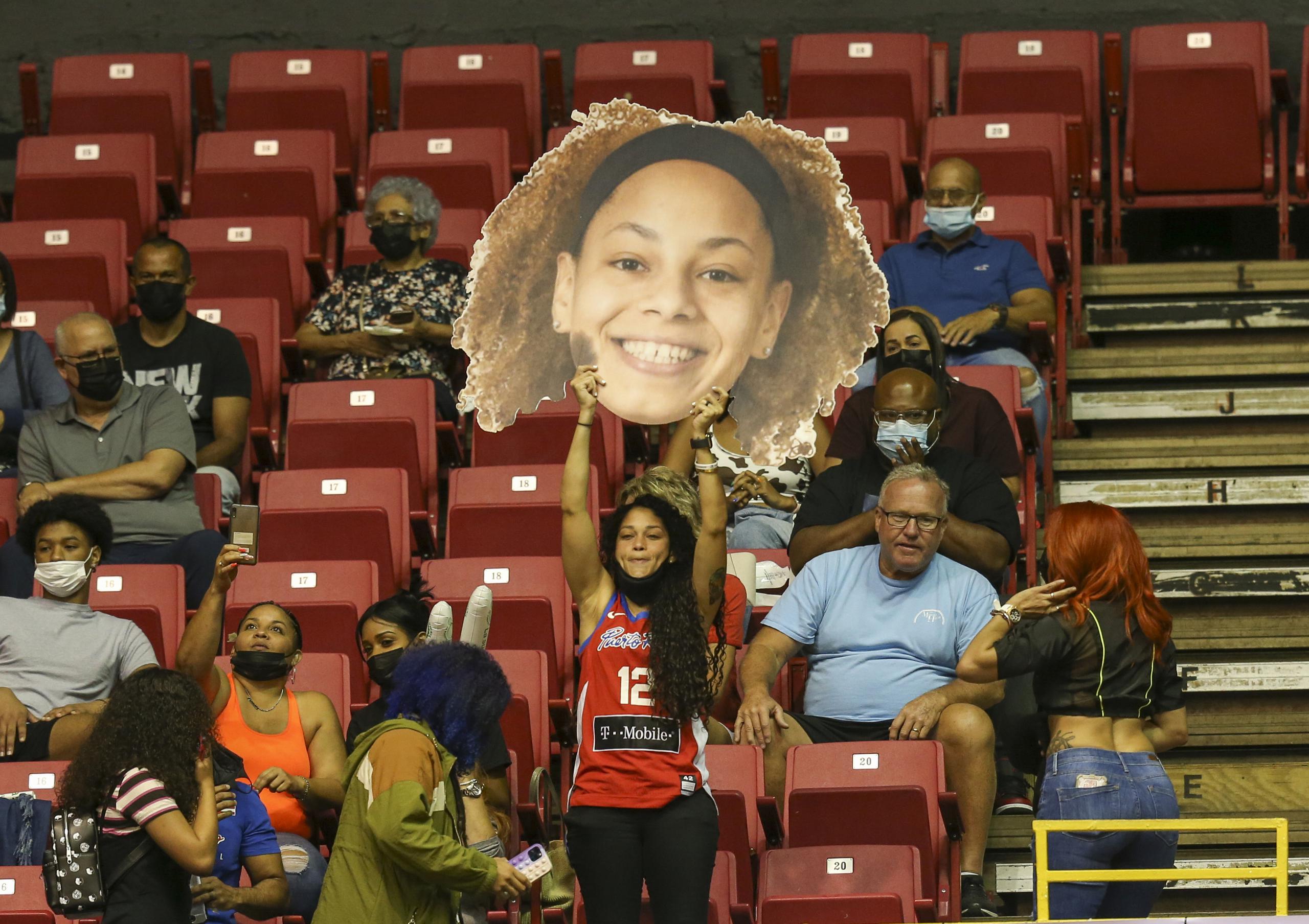 Una seguidora de Puerto Rico levanta un cartel del rostro de la jugadora Dayshalee Salamán durante el choque ante Argentina.