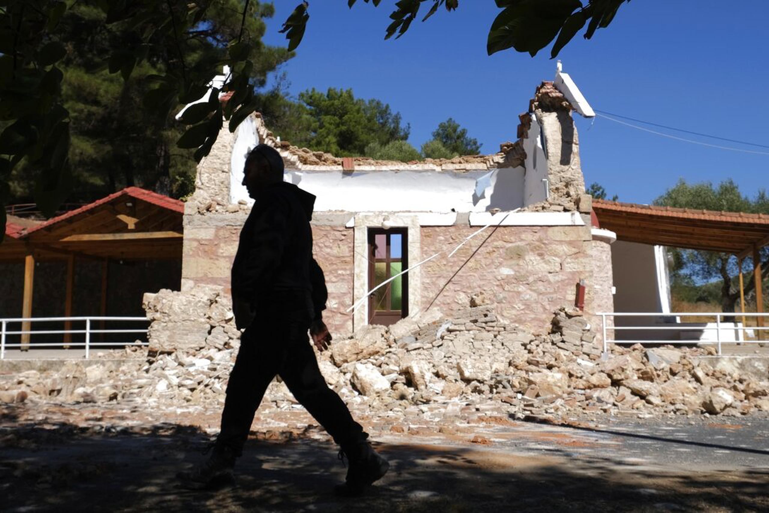 Un vecino pasa junto a una capilla griega dañada por el fuerte sismo en el poblado de Arcalochori, en la isla sureña de Creta, el 27 de septiembre de 2021.