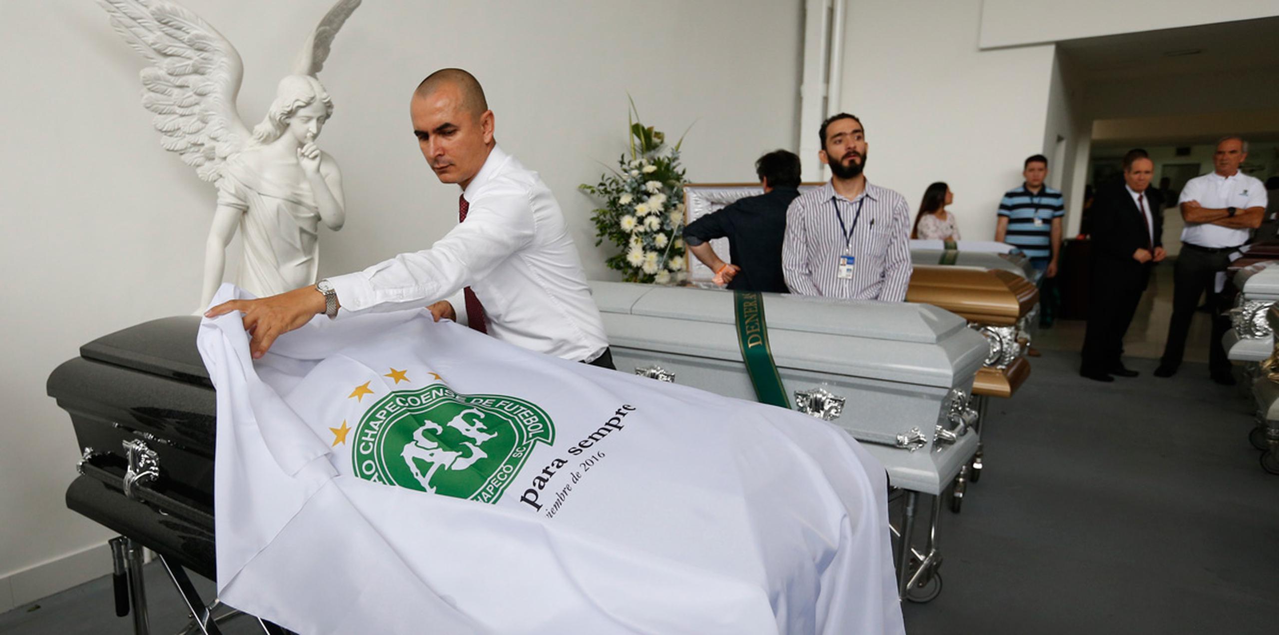 El jueves, sábanas blancas con el logo del club cubrían una fila de féretros en una funeraria de Medellín.  (AP)