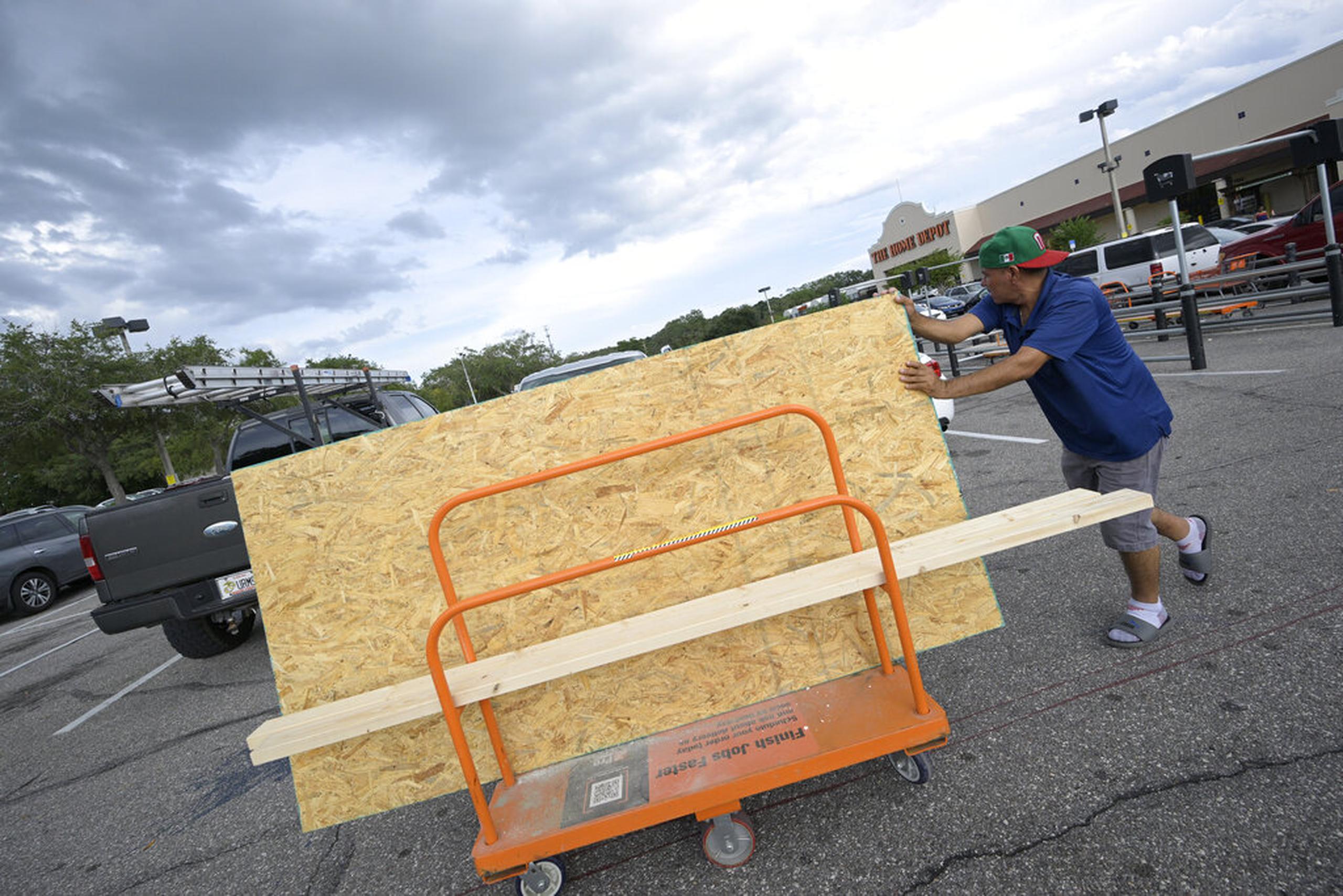 Jesús Rodrigues lleva madera a su vehículo afuera de una tienda Home Depot en preparación para la llegada del huracán Ian, el 26 de septiembre de 2022 en Orlando, Florida.