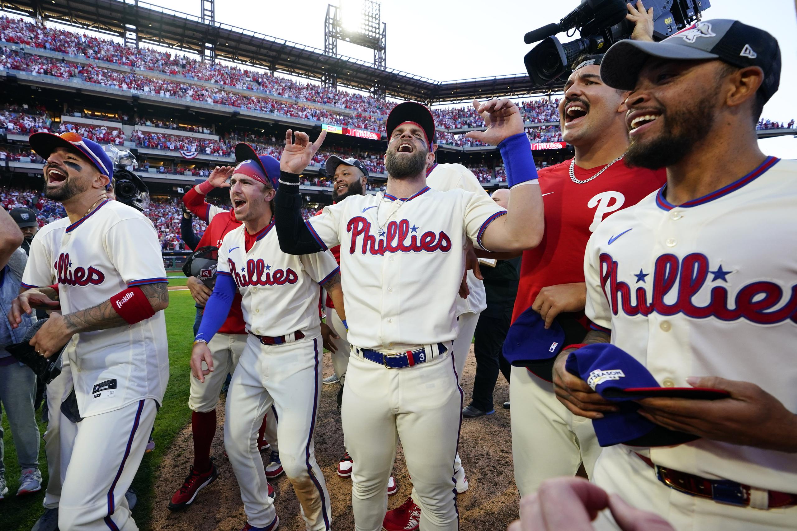 Bryce Harper, al centro, se disfruta la celebración de los Phillies de Filadelfia frente a sus fanáticos luego de que eliminaran el sábado a los Braves de Atlanta para adelantar a la Serie de Campeonato de la Liga Nacional.