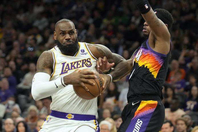 LeBron James hace un movimiento ante la defensa de un jugador de los Suns.