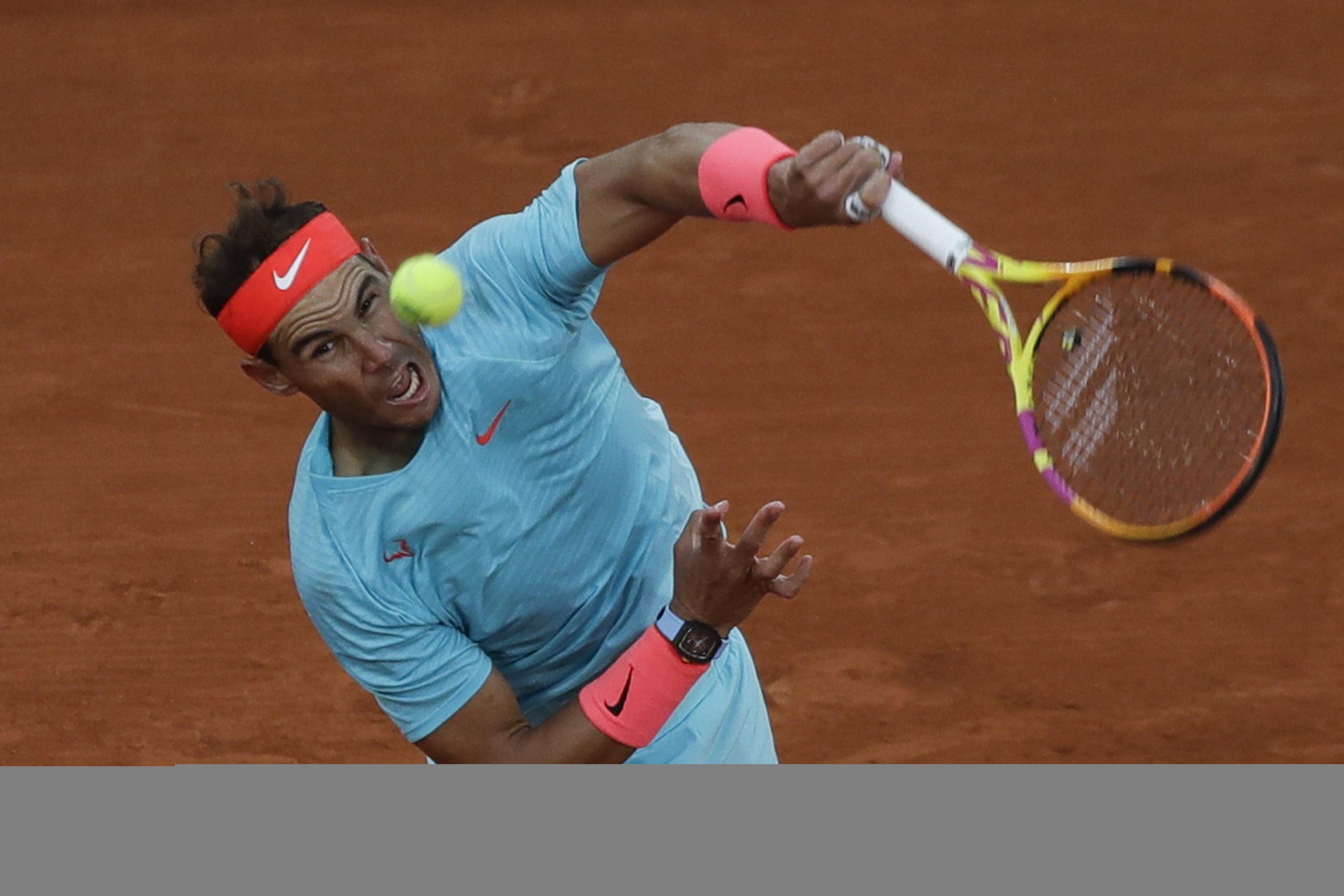 Rafael Nadal es todo mueca y esfuerzo al realizar un servicio durante su partido de primera ronda este lunes en el Roland Garros.