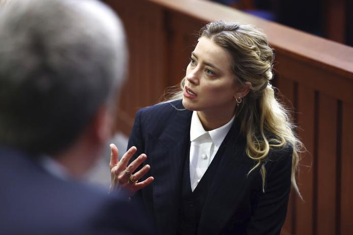 La actriz Amber Heard habla con su equipo legal en la sala del tribunal del Tribunal de Circuito del condado de Fairfax en Fairfax, Virginia, el 21 de abril de 2022.