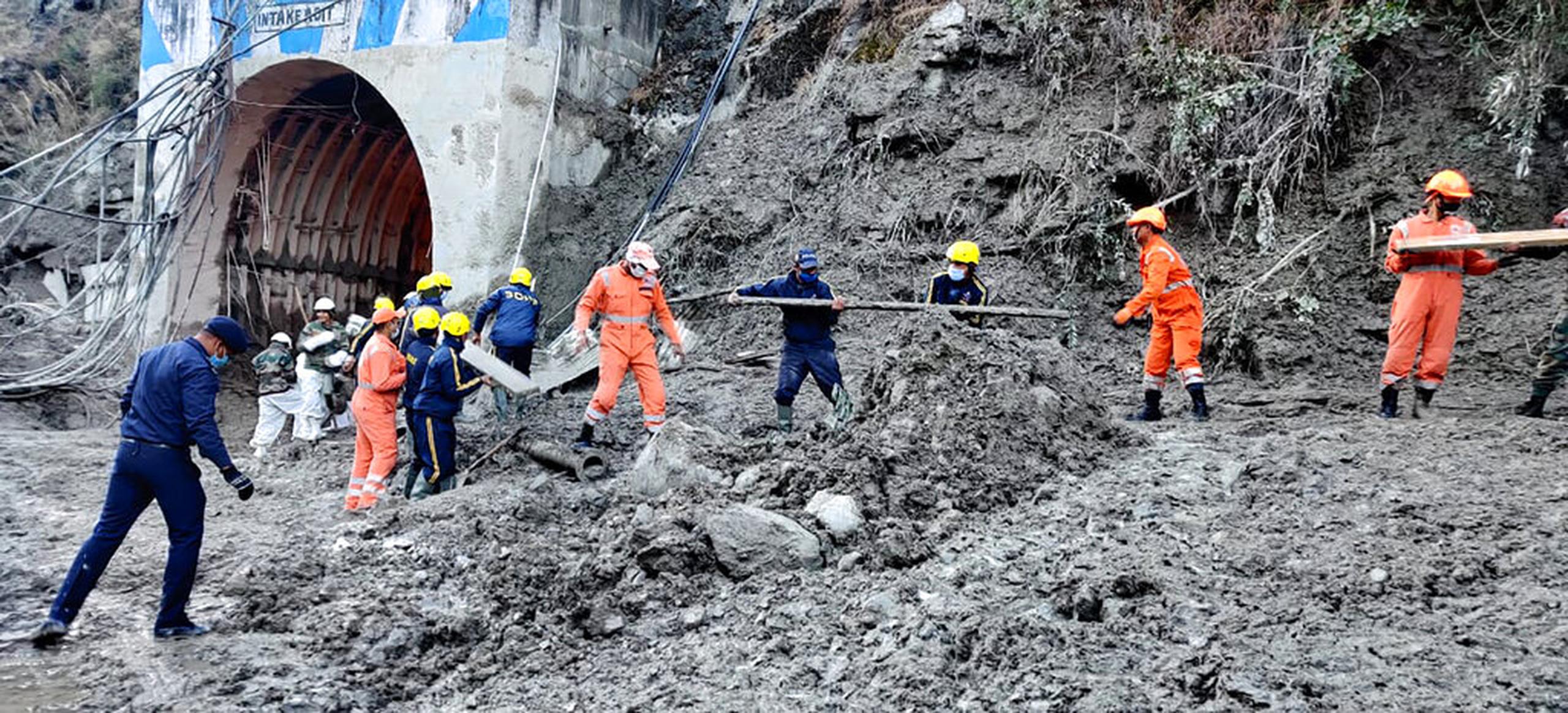 Miembros de la Fuerza Nacional de Respuesta a Desastres buscan a los trabajadores de una central hidroeléctrica en el poblado de Reni.