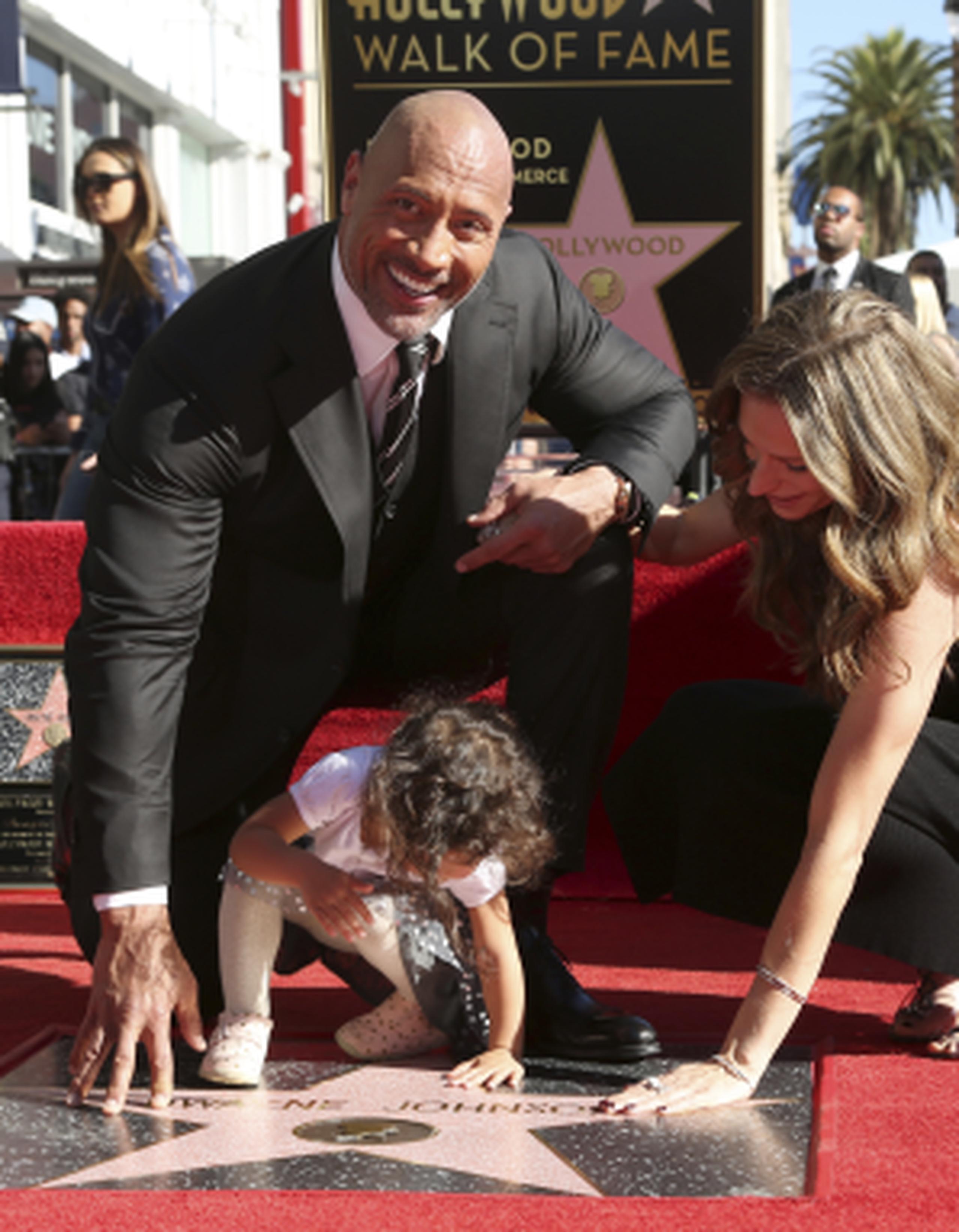 Johnson, su esposa Lauren Hashia, y su hija Jasmine, tocando su estrella en el famoso paseo. (AP)