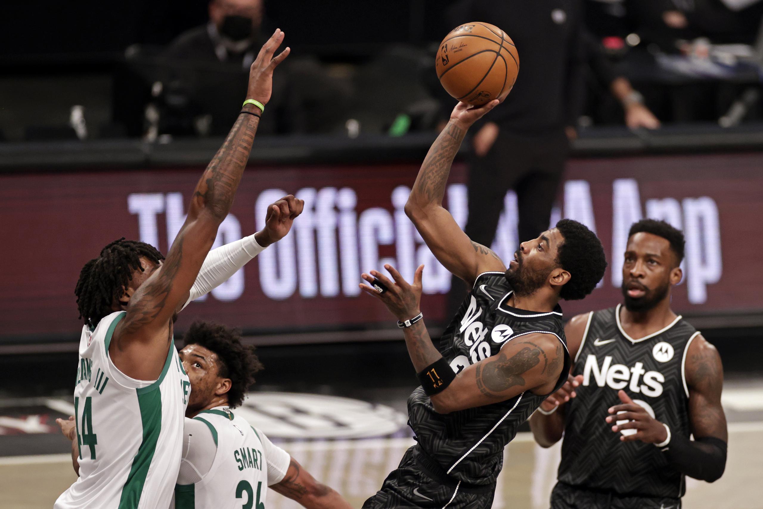 Kyrie Irving, de los Nets de Brooklyn, intenta un tiro en flotadora sobre Robert Williams III, de los Celtics de Boston.
