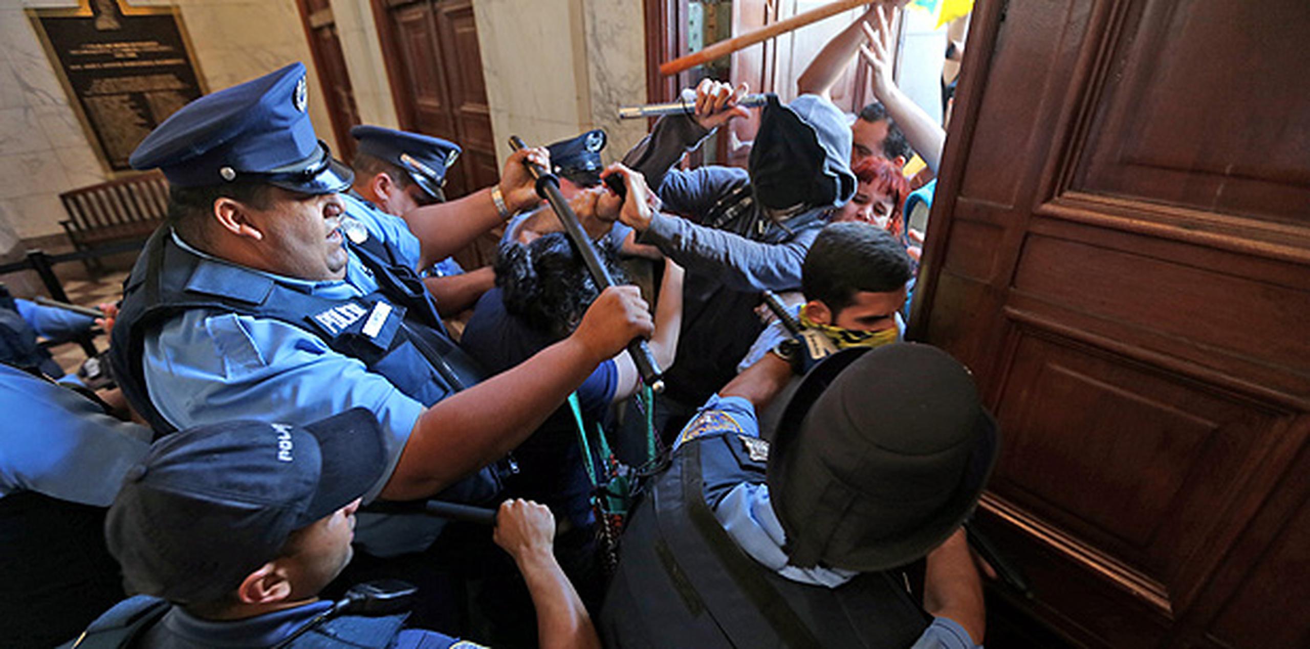 En la escaramuza, los manifestantes tumbaron las vallas que dividían a la Policía de los manifestantes. (juan.martinez@gfrmedia.com)