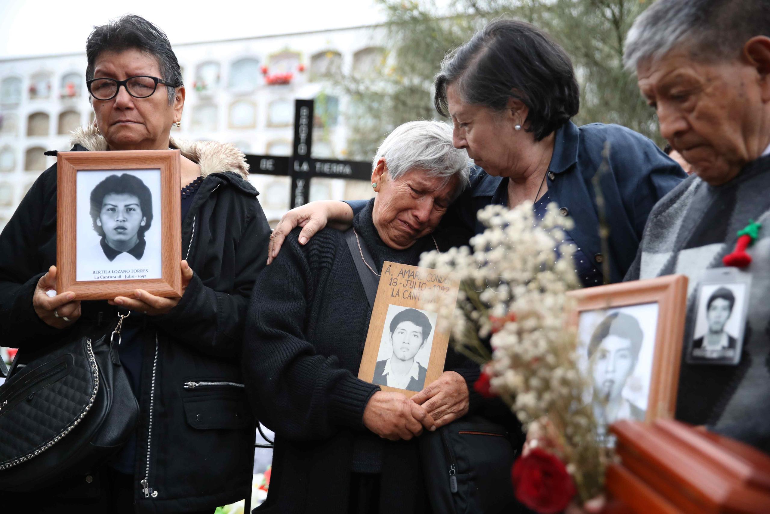 Familiares sostienen retratos de víctimas de la matanza de La Cantuta durante su funeral hoy, en Lima (Perú), 31 años después de los crímenes por los que el expresidente Adalberto Fujimori cumple una condena en prisión..