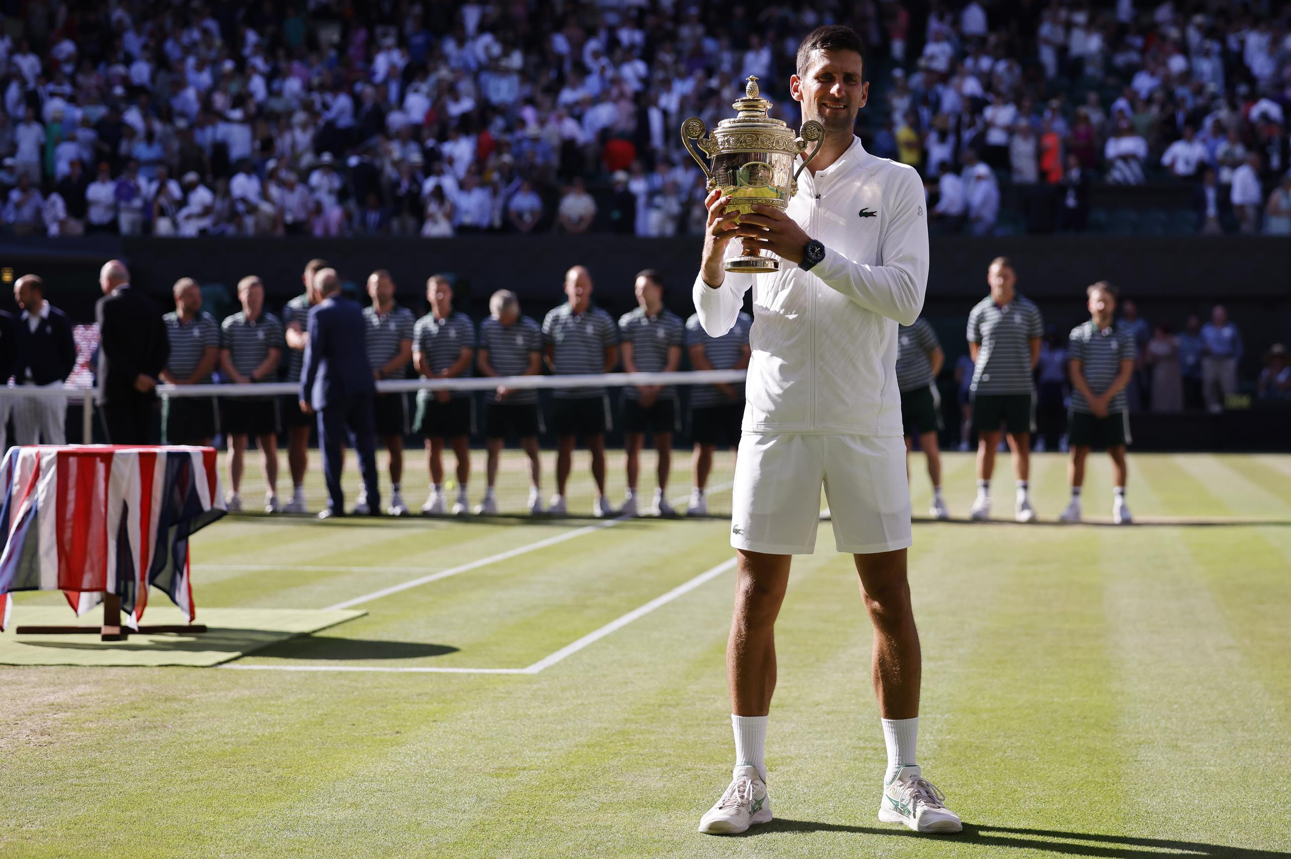 Novak Djokovic levanta la copa del Wimbledon, que marca su vigésimo primer título de grande slam, uno por debajo de Rafael Nadal y uno por encima de Roger Federer.
