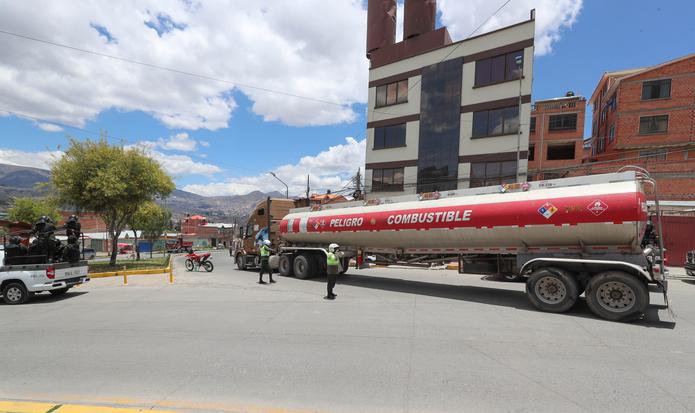 Ciudadanos bolivianos observan este martes el paso de la caravana de camiones cisterna de combustible de la empresa estatal Yacimientos Petrolíferos Fiscales Bolivianos (YPFB), que llegan a La Paz, (Bolivia). Un operativo de militares y policías despejó el acceso a la refinería en la ciudad boliviana de El Alto, entre incidentes con manifestantes partidarios de Evo Morales, para escoltar los camiones cisterna hacia La Paz. El Alto es la segunda mayor ciudad de Bolivia, con cerca de un millón de habitantes, y es uno de los bastiones electorales de Morales, en una urbe con tan solo 34 años de existencia en la que residen muchos emigrantes de zonas rurales. EFE/ Martín Alipaz