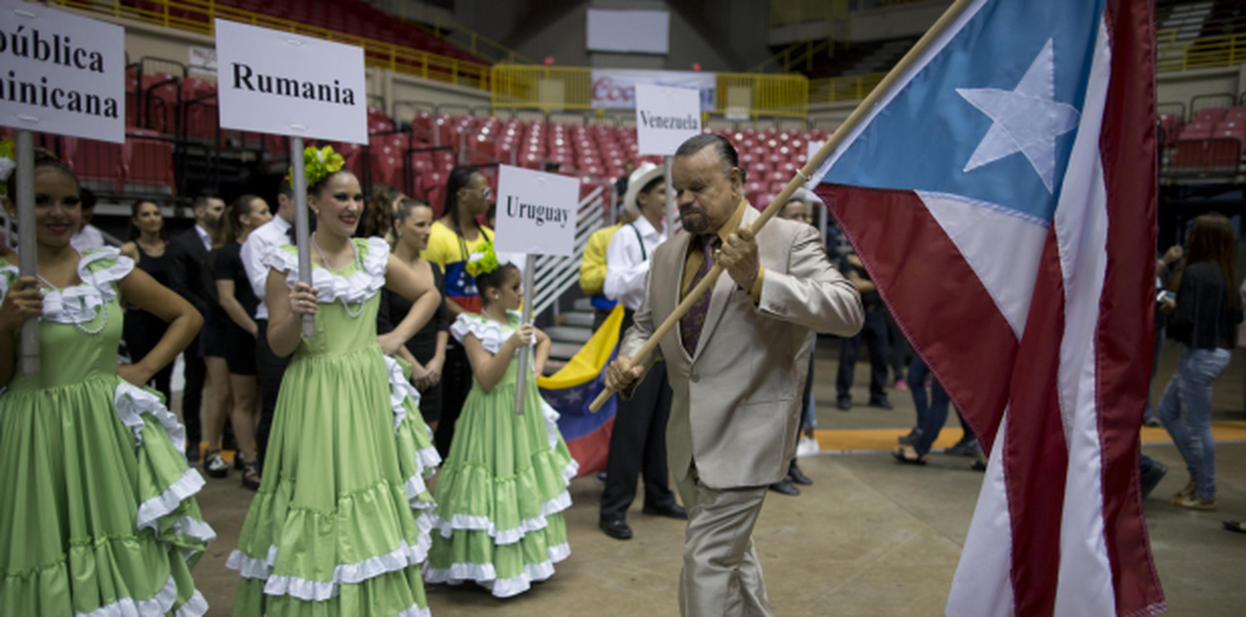 El bailarín Mike Rivera carga la bandera de Puerto Rico durante el desfile de delegaciones. (teresa.canino@gfrmedia.com)