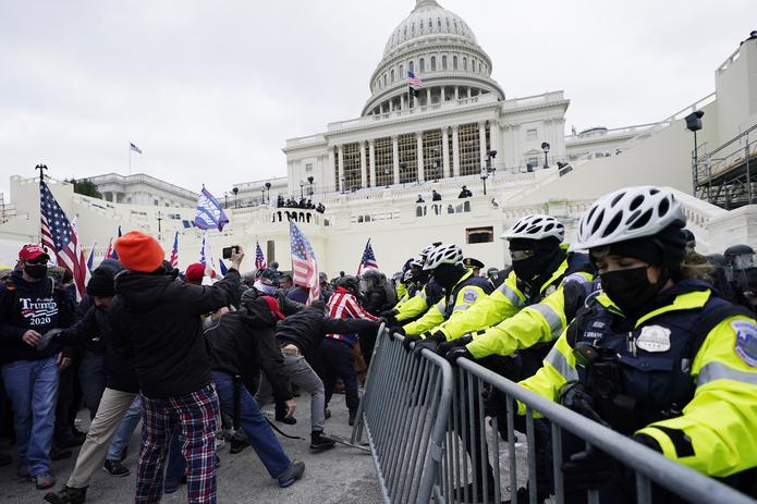 Momento en que los simpatizante de Donald Trump trataban de pasar la barricada de la Policía frente al Capitolio.