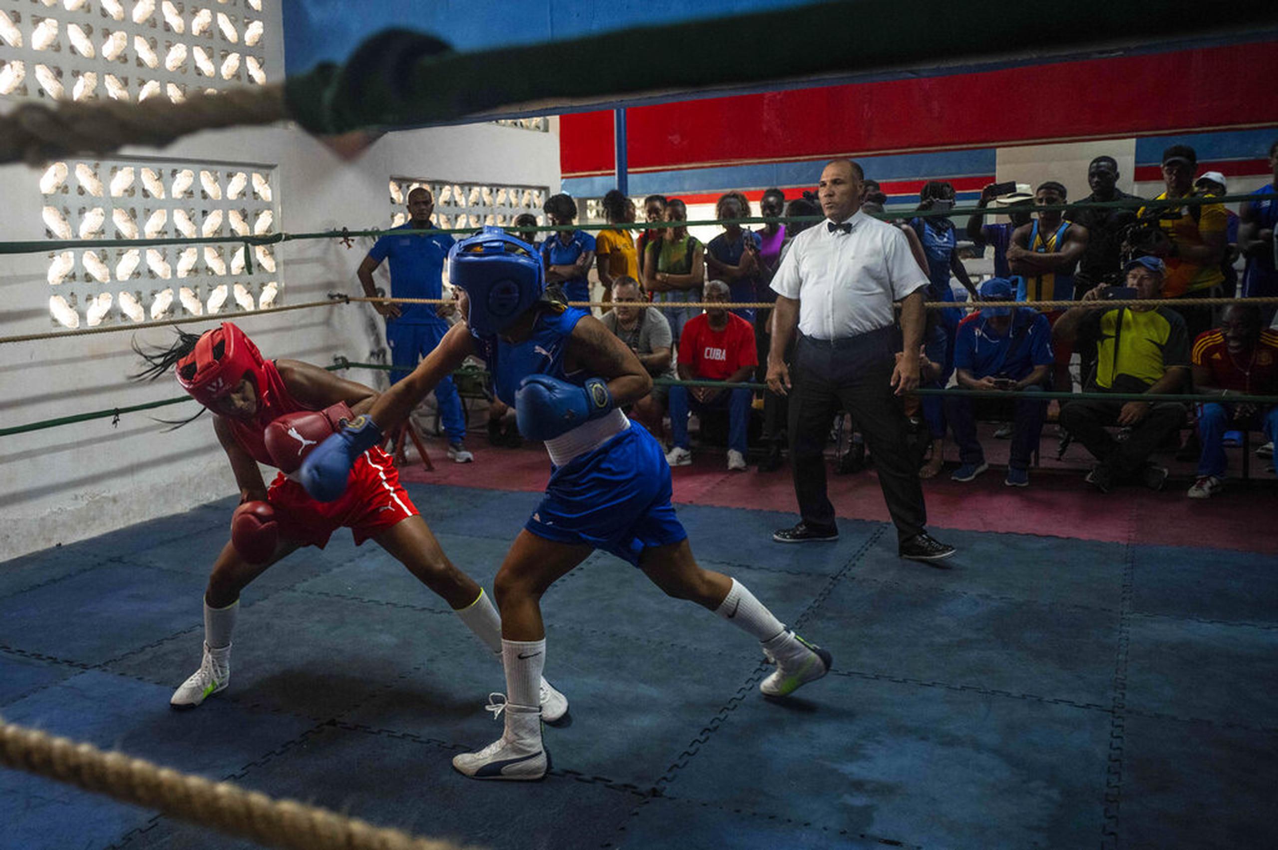 Ydamelys Moreno, izquierda, esquiva un golpe de su oponente en el primer programa oficial de boxeo femenino cubano, en la escuela de boxeo Giraldo Córdova en La Habana, Cuba.