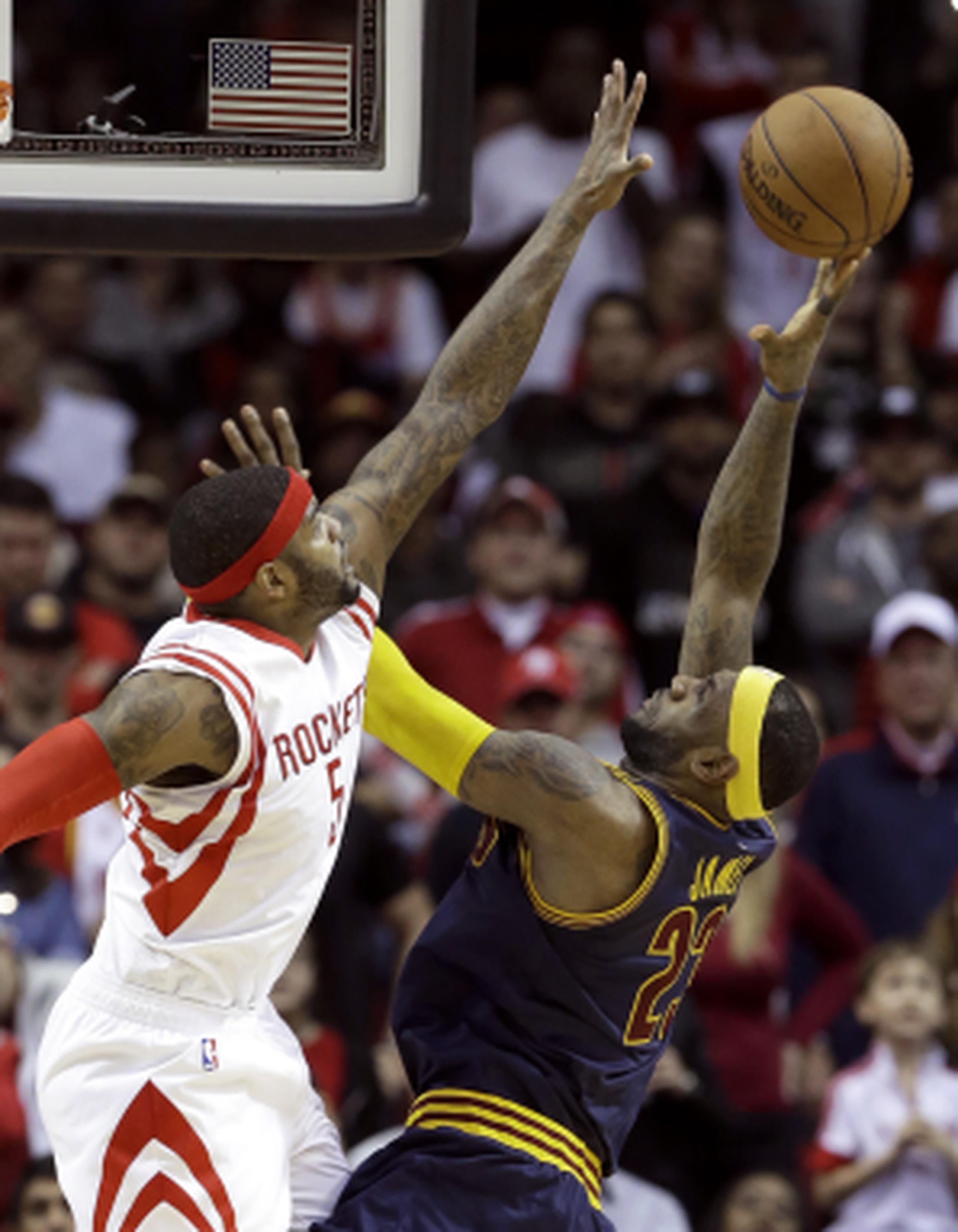 LeBron James intenta un disparo al canasto en el periodo adicional ante la defensa del delantero de los Rockets de Houston, Josh Smith. (AP \ Pat Sullivan)