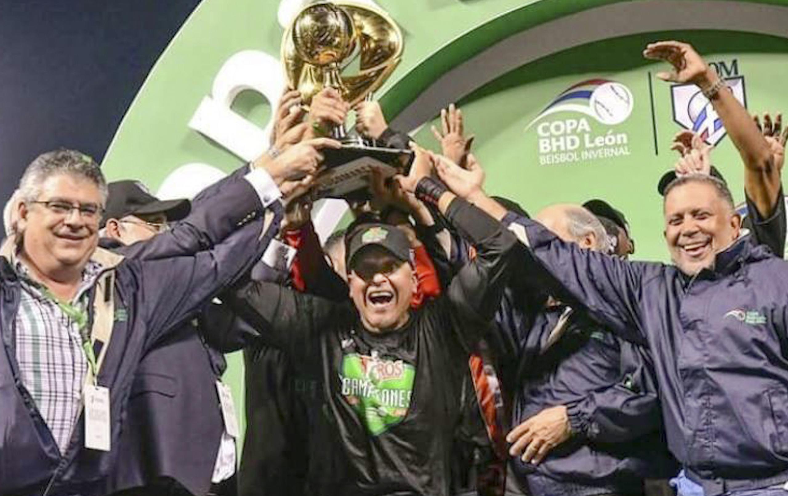Lino Rivera sostiene el trofeo de campeón junto a los directivos de los Toros del Este luego de coronarse campeones en la Liga de Béisbol de República Dominicana.