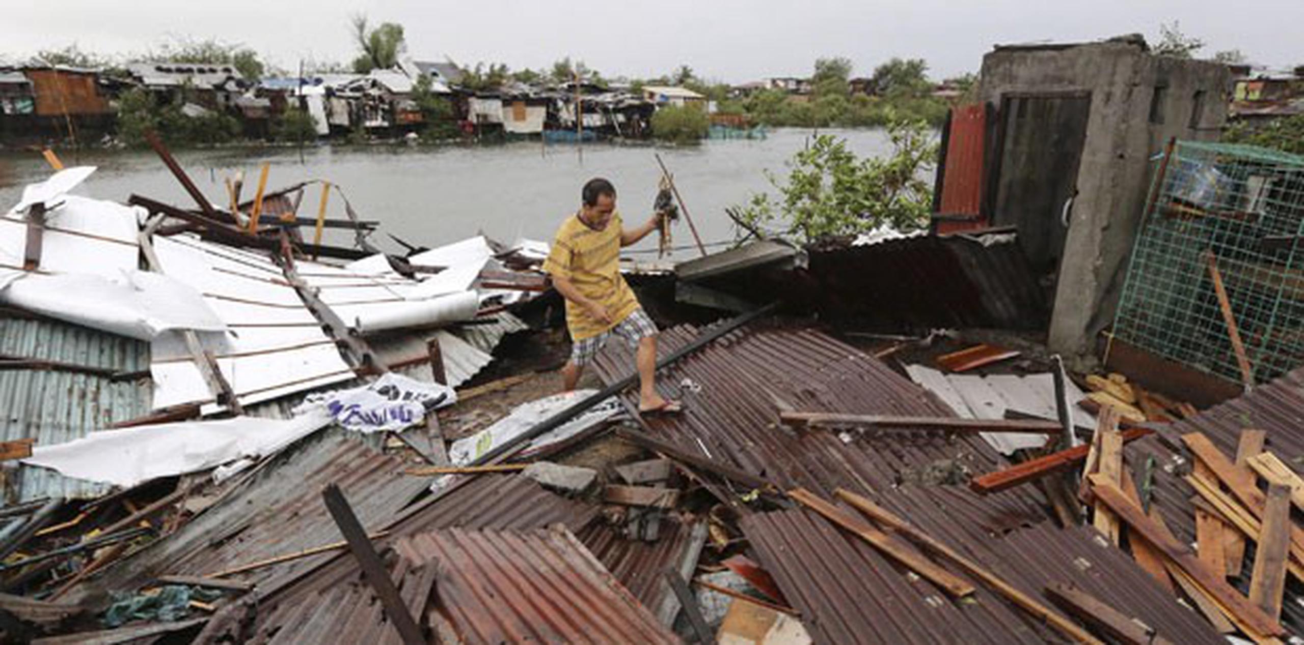 Un lugareño retira escombros tras el paso del tifón por la localidad de Kawit, al sur de Manila. (EFE/Francis R. Malasig)