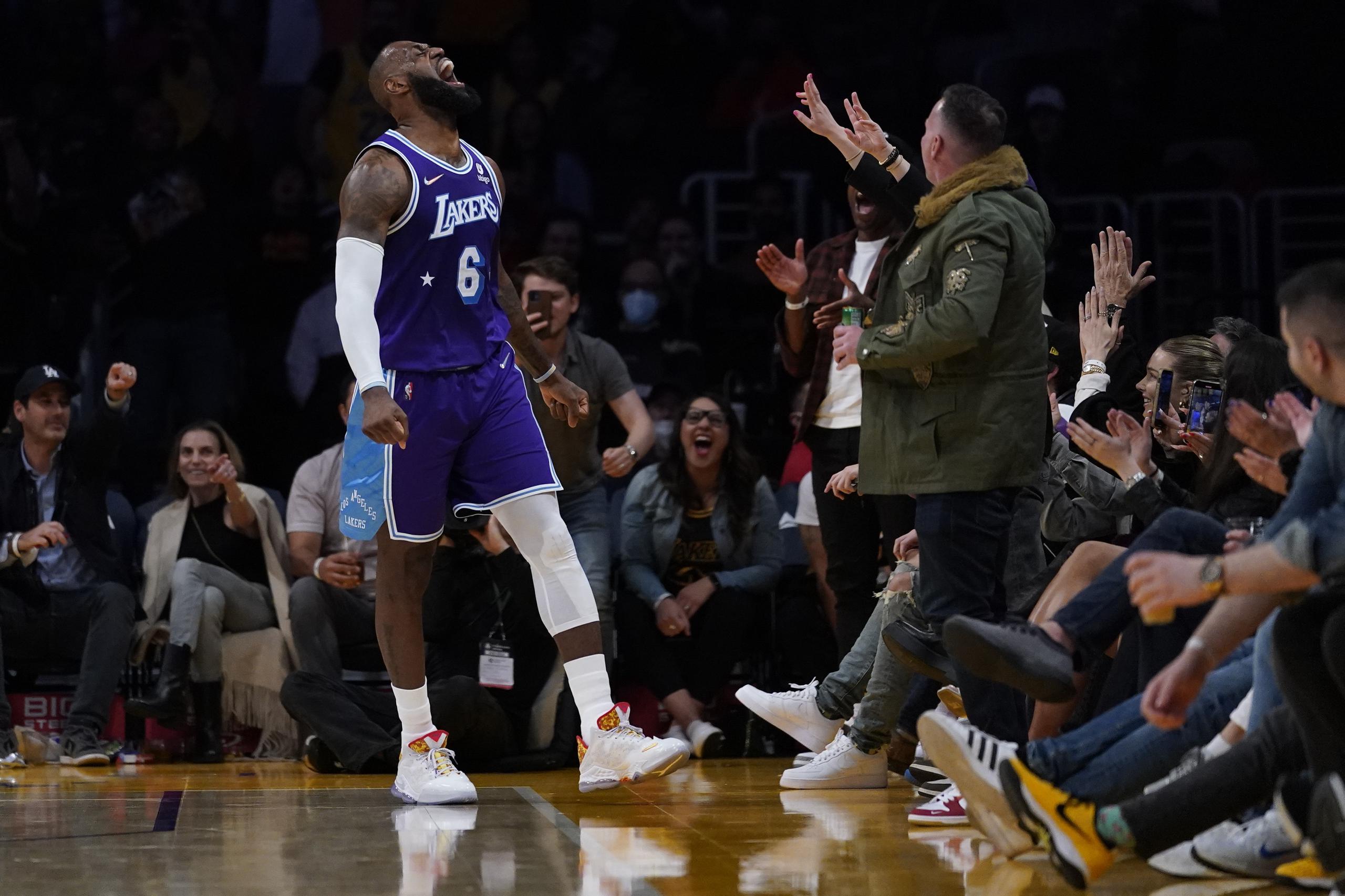 LeBron James reacciona después anotar un canasto de tres puntos durante la segunda mitad del desafío contra los Wizards de Washington.