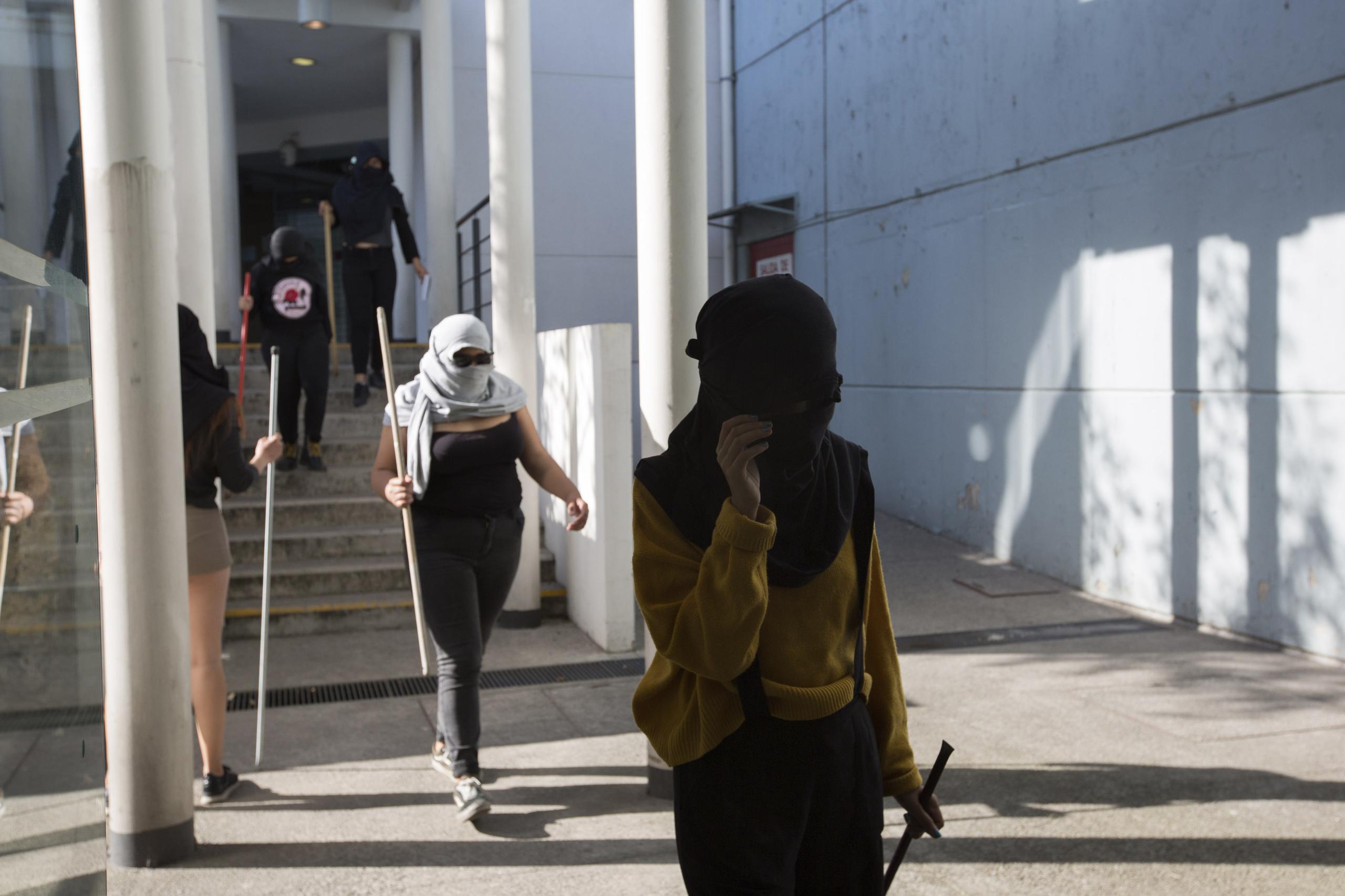 En esta foto del 14 de febrero de 2020, se ve a mujeres armadas con barras de metal y encapuchadas que mantienen tomada la Facultad de Ciencias Políticas y Sociales, de la Universidad Nacional Autónoma de México (UNAM). (AP Foto/Ginnette Riquelme)