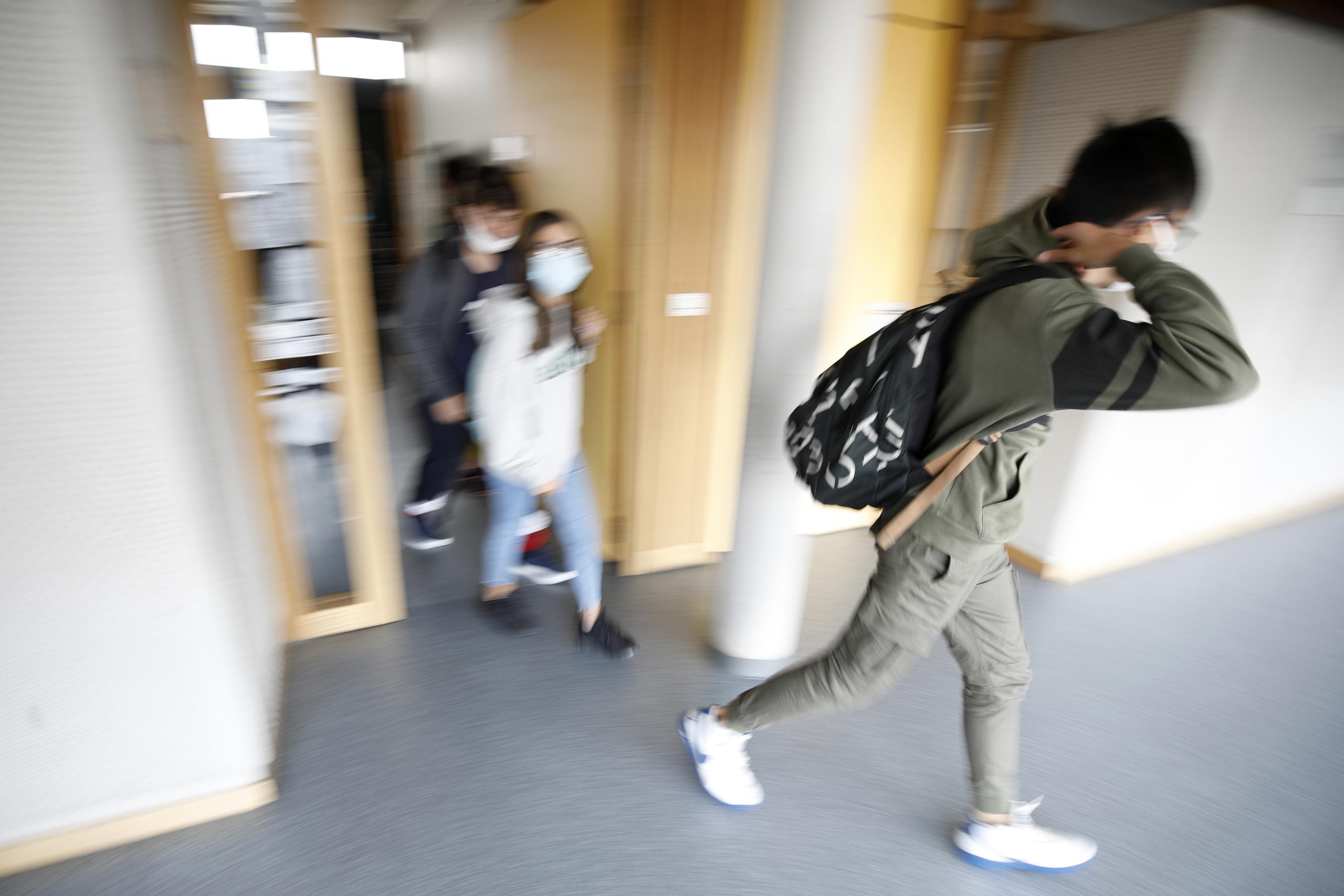 Alumnos con mascarilla salen de su escuela en Bischheim, a las afueras de Estrasburgo, Francia.