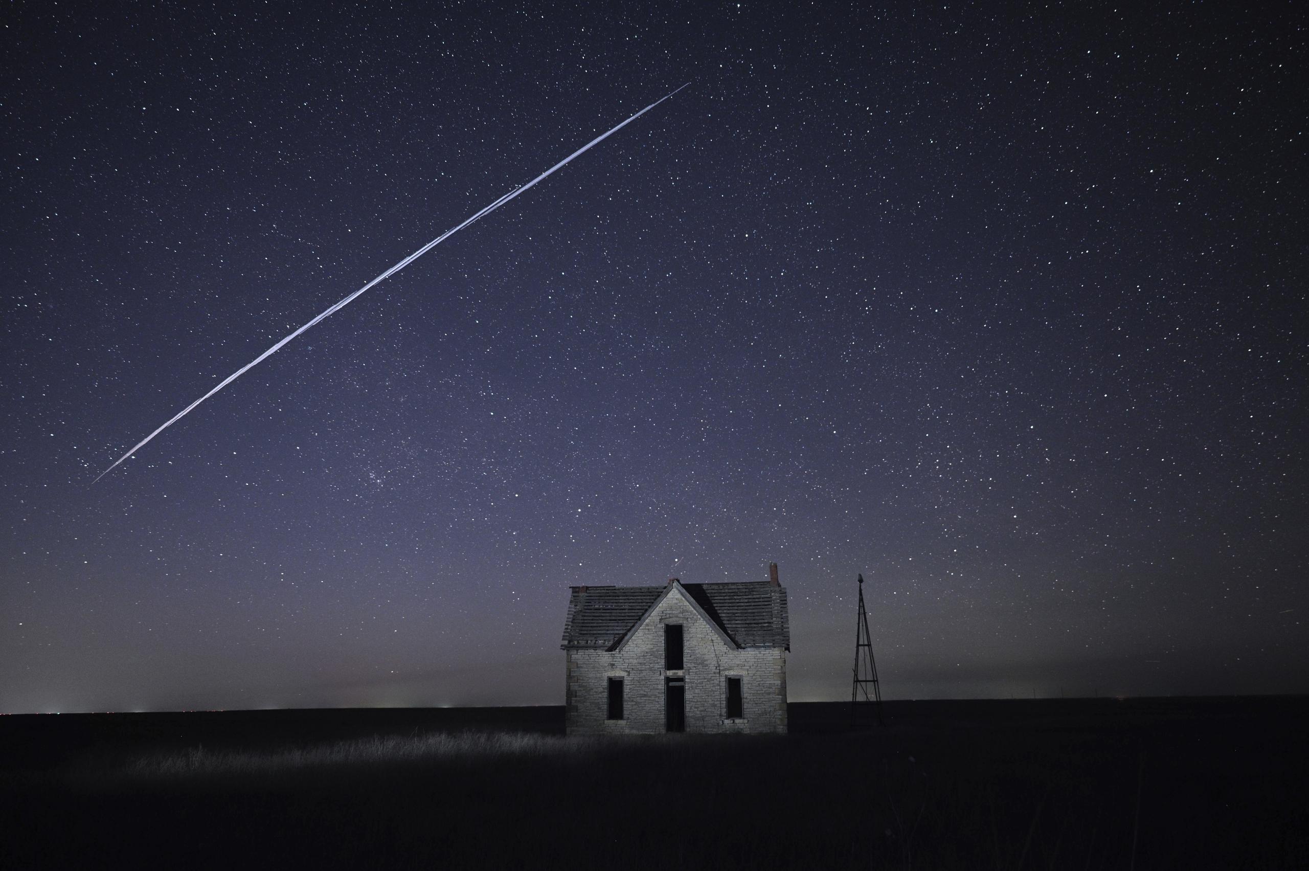Fotografía de larga exposición de una serie de satélites StarLink de SpaceX sobre una casa cerca de Florence, Kansas.