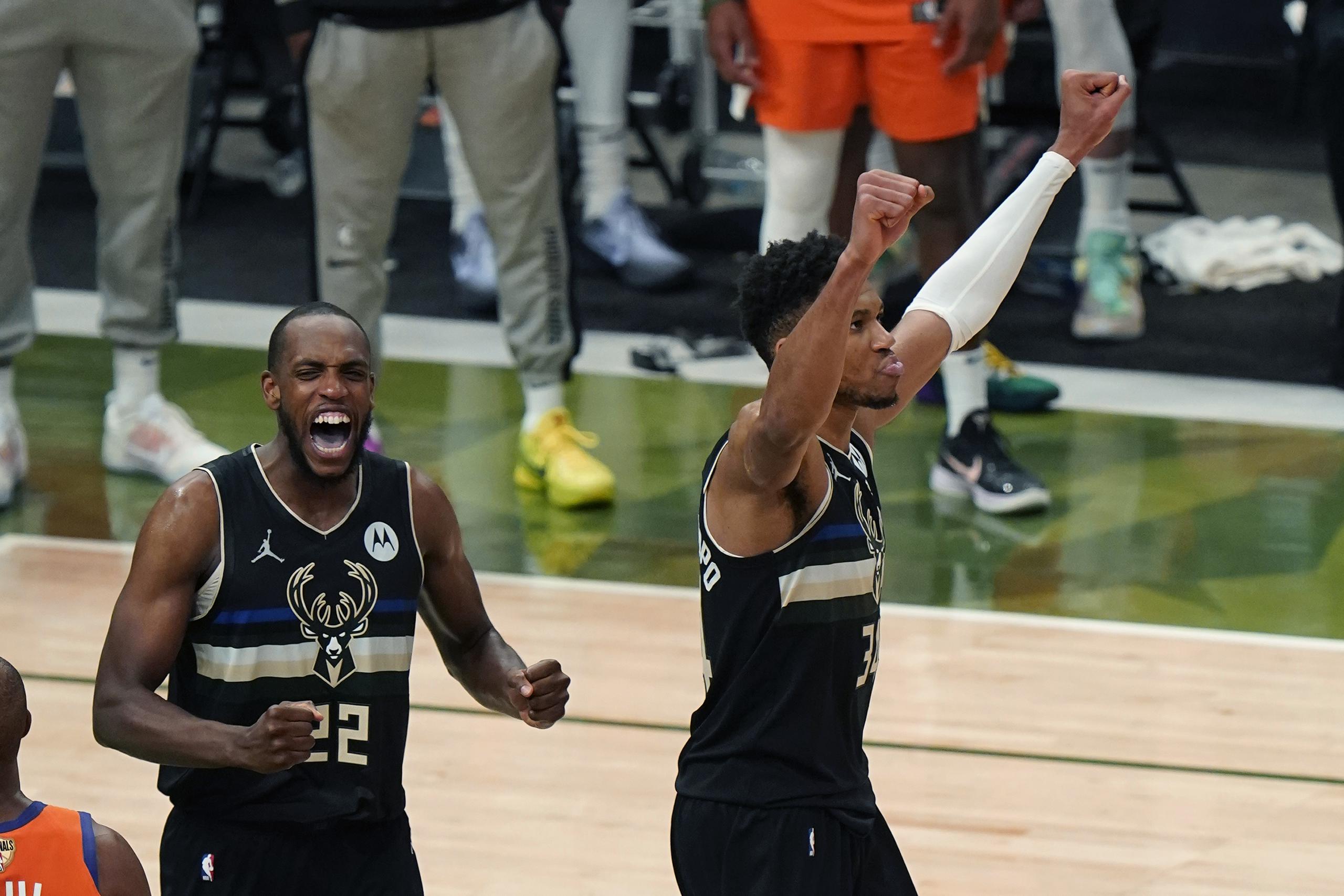 Khris Middleton (22) y Giannis Antetokounmpo inician la celebración mientras expira el tiempo y los Bucks se coronan como campeones de la NBA.
