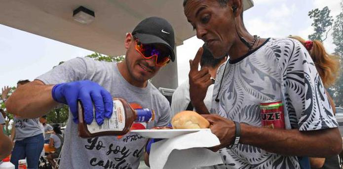 Un voluntario de Puerto Rico Cambia le sirve comida a una persona sin hogar en la estación de Centro Médico del Tren Urbano. (LUIS.ALCALADELOLMO@GFRMEDIA.COM)