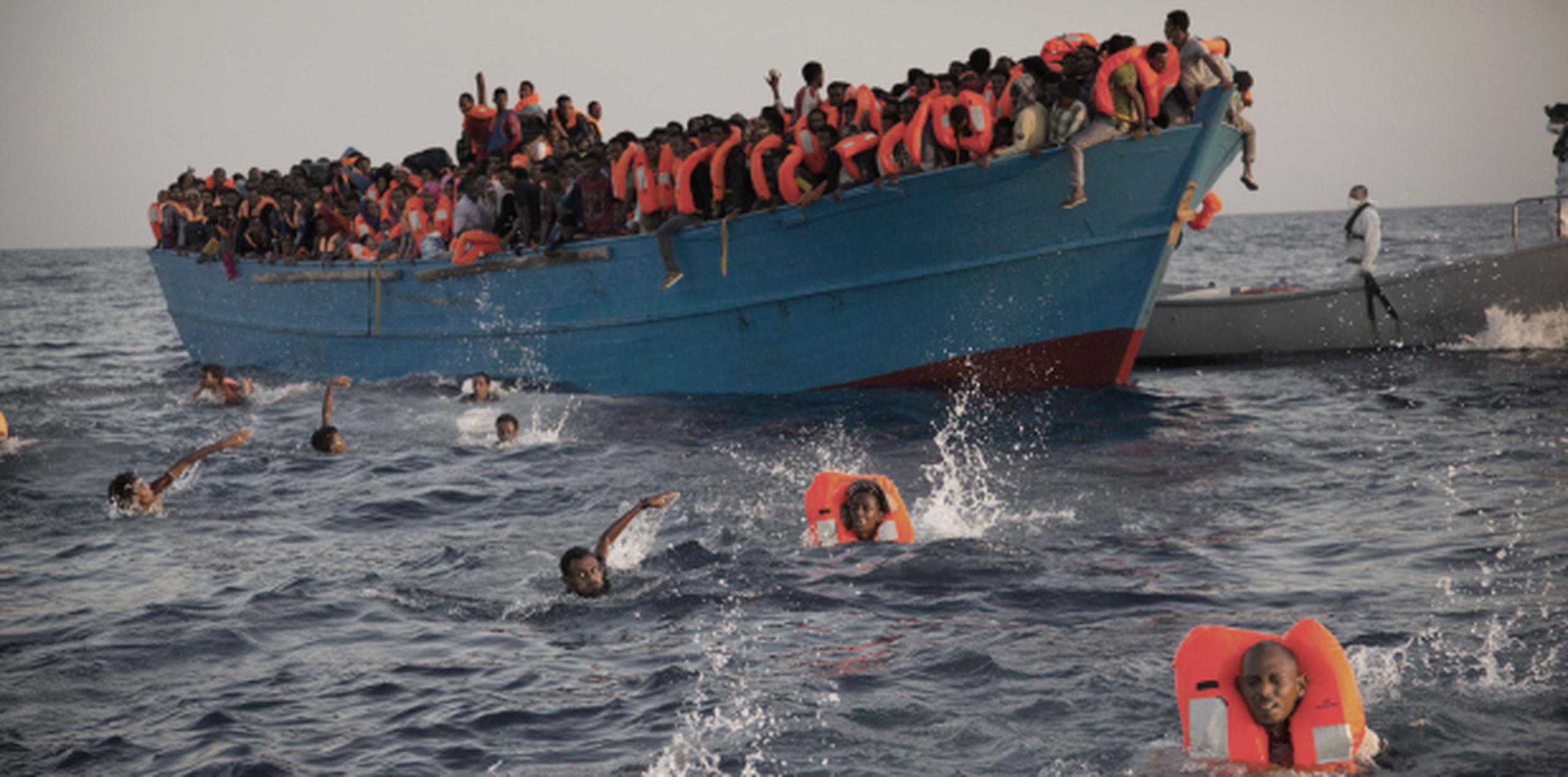 Decenas de migrantes, en su mayoría procedentes de Eritrea, aguardan en un abarrotado bote y en aguas del Mediterráneo por miembros de una organización no gubernamental que realiza rescates. (AP/Emilio Morenatti)
