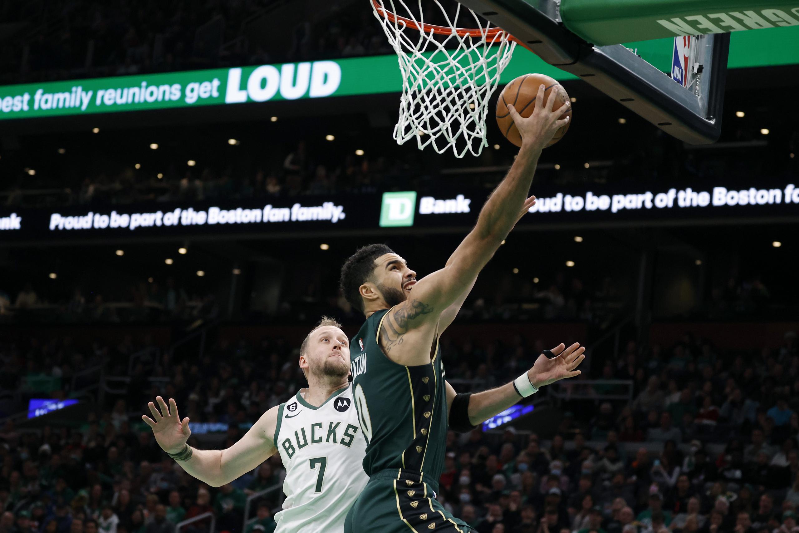 El alero de los Celtics de Boston Jayson Tatum avanza hacia la canasta para anotar frente el base de los Bucks de Milwaukee Joe Ingles en el encuentro del domingo 25 de diciembre del 2022. (AP Foto/Mary Schwalm)