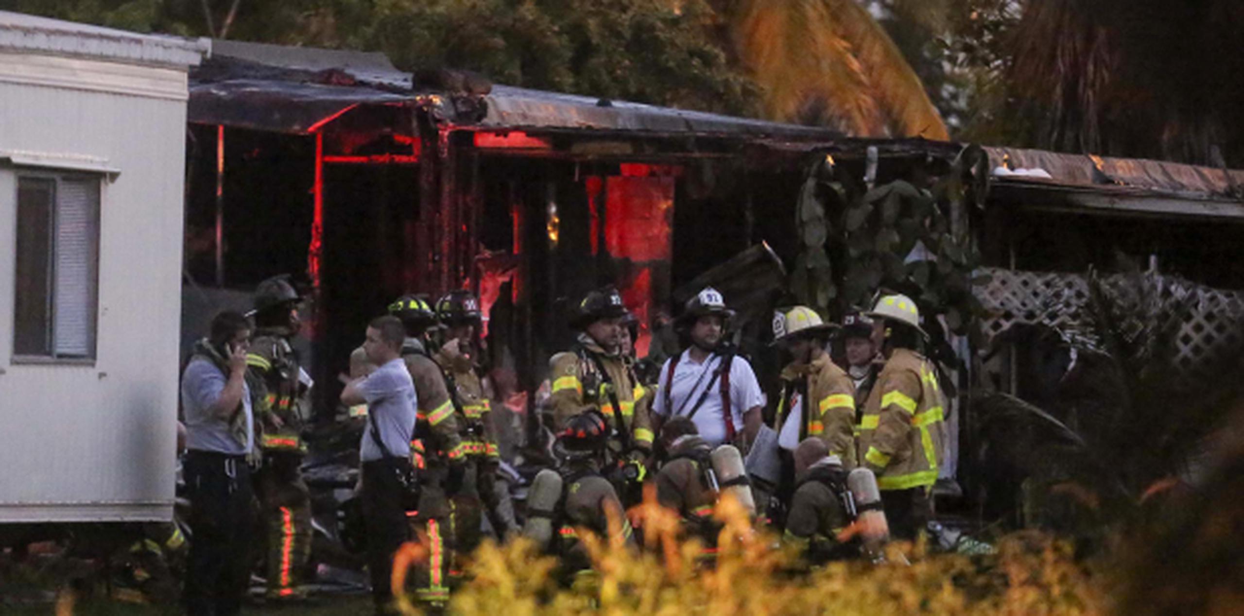 Bomberos en la escena del avión que cayó sobre unas residencias en Florida. (AP)