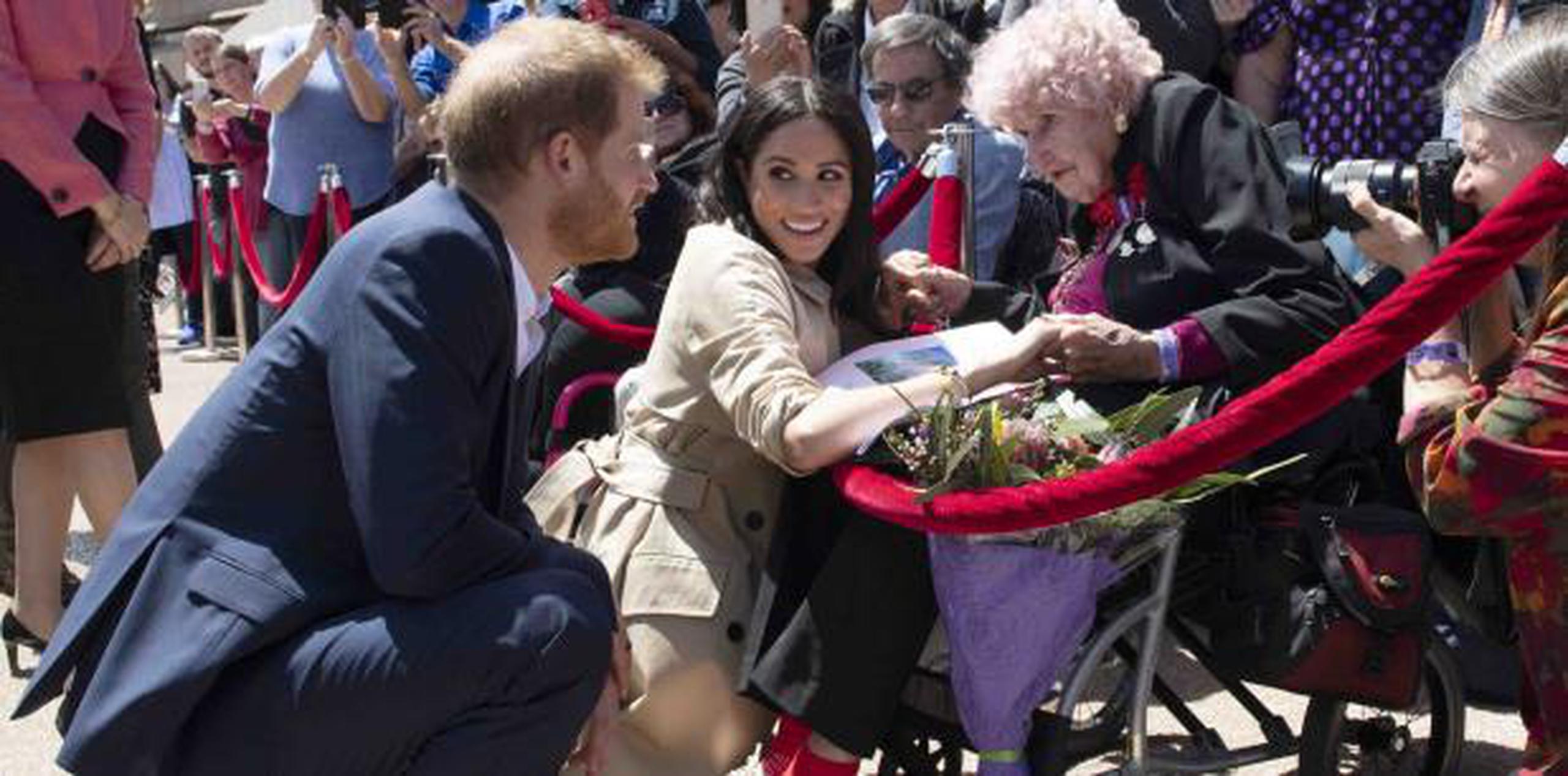 El príncipe y su esposa se ponen de cuclillas para saludar a una fanática de 98 años en Australia. (AP)