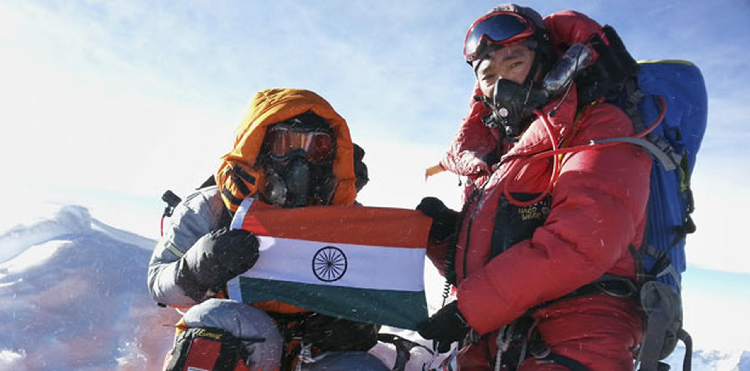 Malavath Poorna y un miembro de su equipo aguantan la bandera de India en el tope de Everest. (Prensa Asociada)
