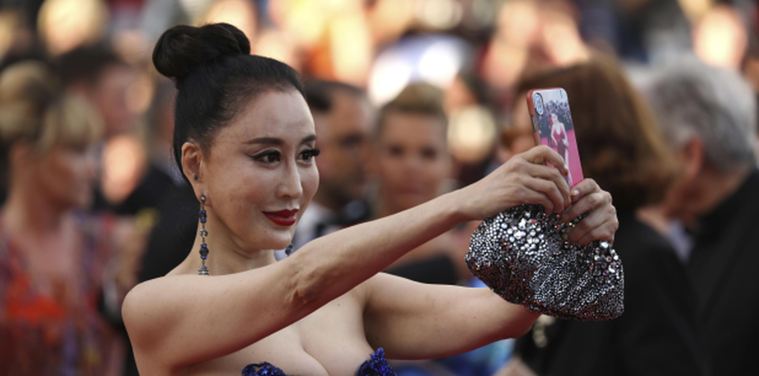 Una invitada se toma un "selfie" al llegar a la ceremonia inaugural del Festival de Cine de Cannes. (Vianney Le Caer / Invision / AP)
