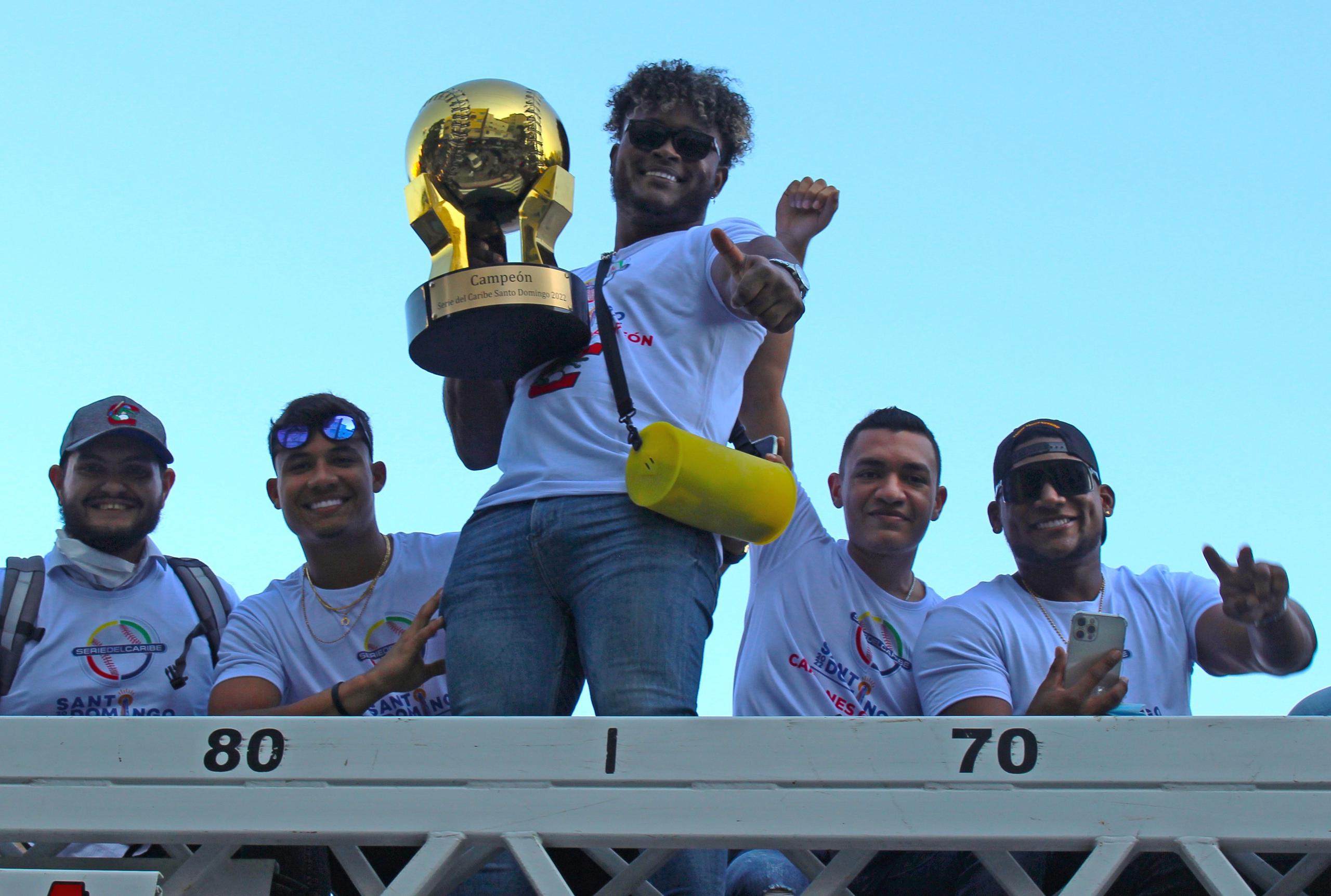 Dilson Herrera sostiene el trofeo de campeón de la Serie del Caribe junto a varios compañeros de los Caimanes de Barranquilla en la caravana de recibimiento del sábado.