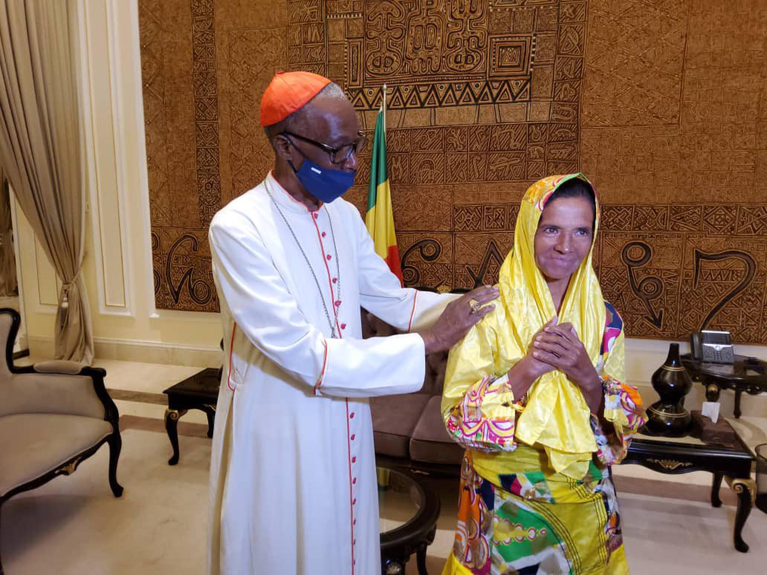 Las fotos publicadas en el perfil de Twitter de la presidencia de Mali muestran a Gloria Narváez en un vestido y pañuelo amarillos, uniendo sus manos y sonriendo junto al presidente interino maliense Assimi Goita.