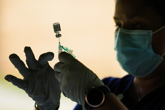 Una trabajadora de salud prepara una jeringuilla con la vacuna de Pfizer para el COVID-19.