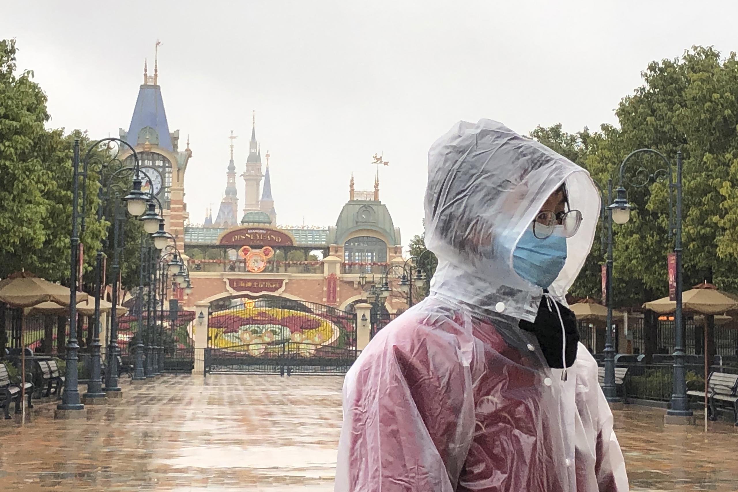 Una empleada de Disney en Shanghai Disney Resort frente a los portones del cerrado parque.
