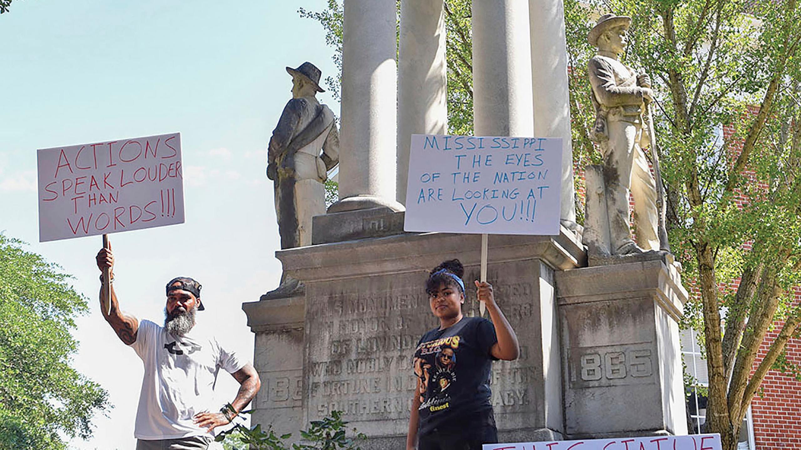 John Lewis, a la izquierda, y Sonniah Ramirez, de 12 años, protestan para retirar un monumento confederado ubicado en terrenos de la corte del condado de Lowndes, en Columbus, Mississippi