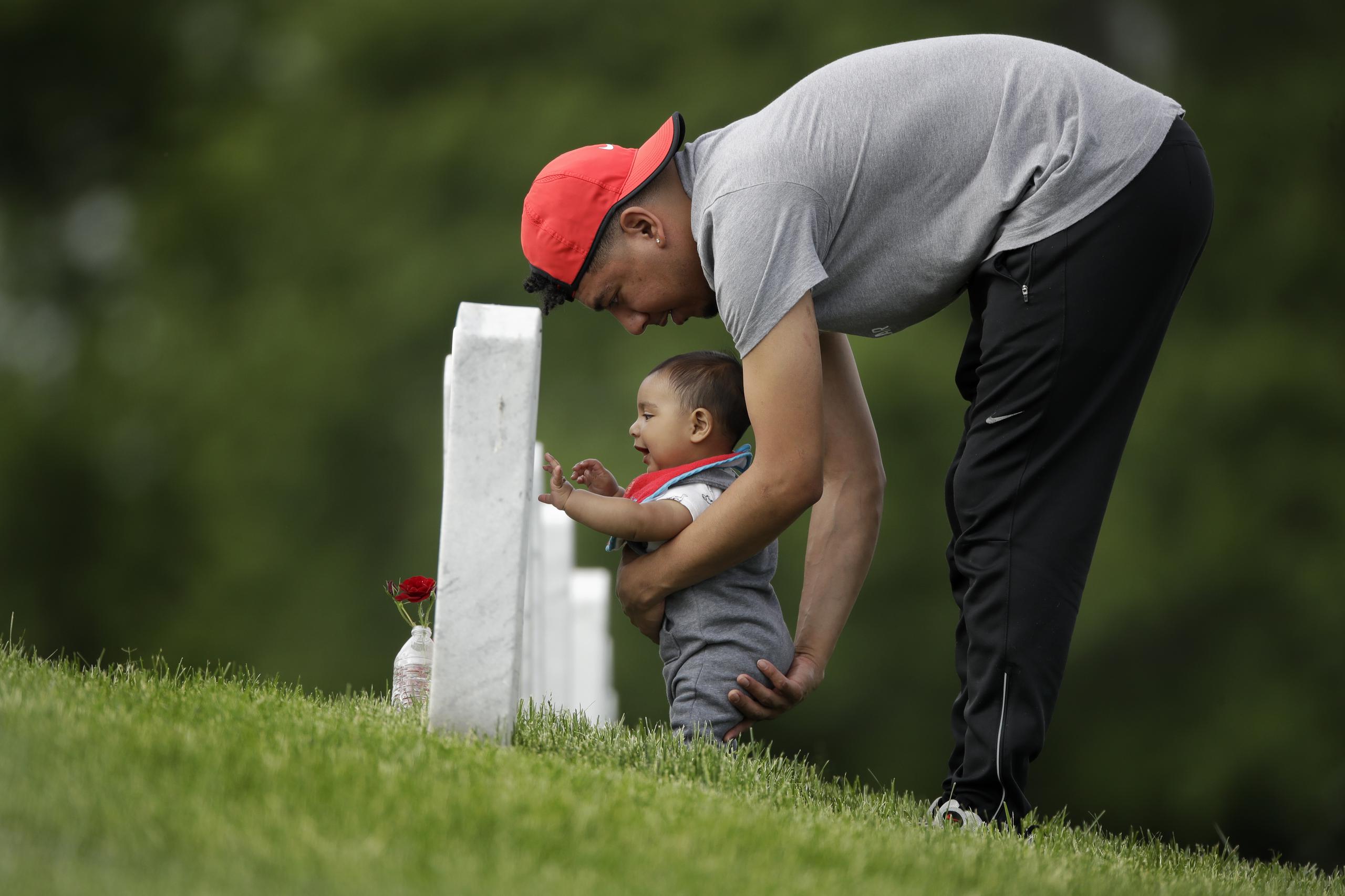 Un hombre visita con su hijo la tumba de su abuelo en Kansas.