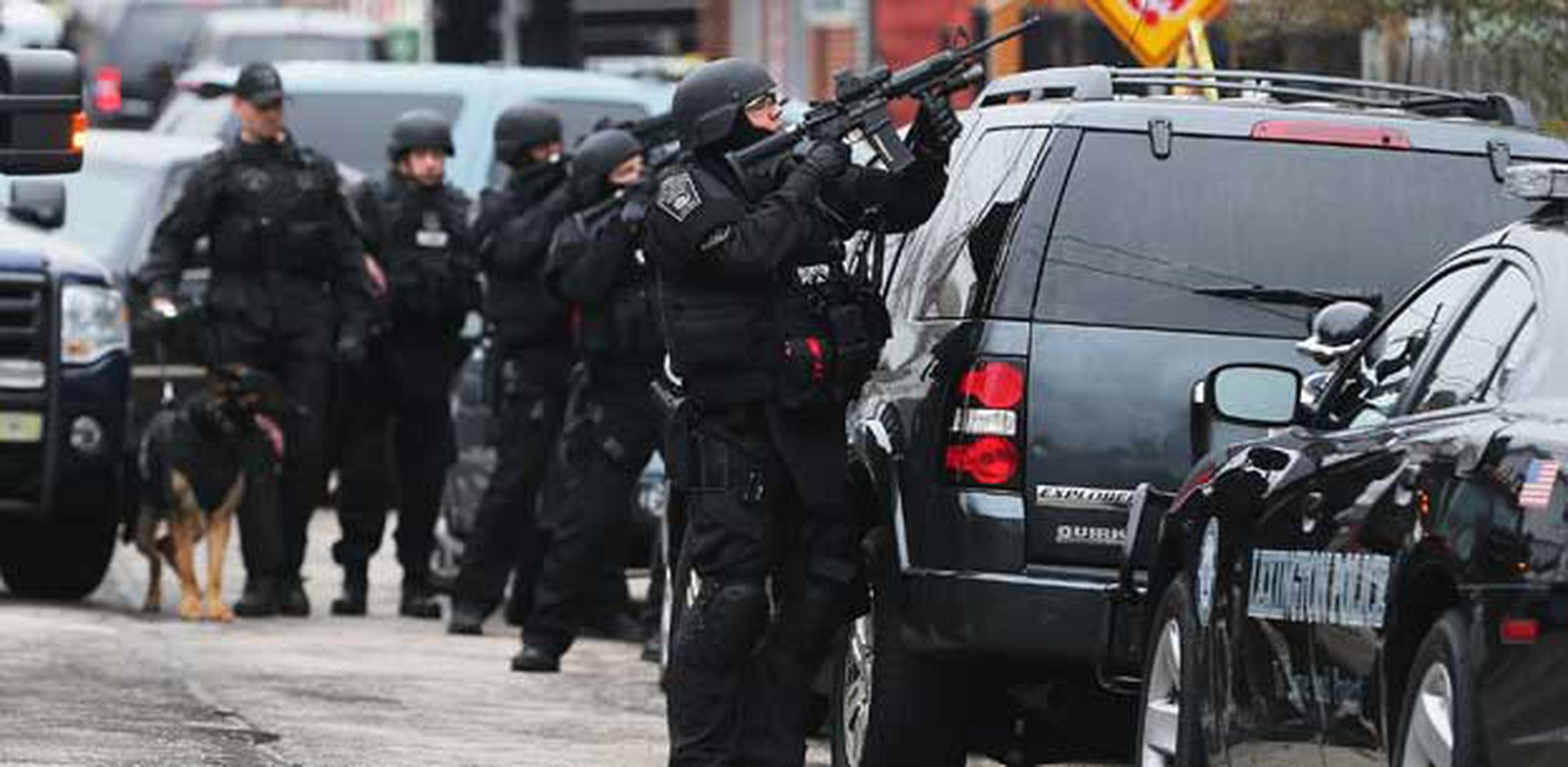 Miembros del SWAT tienen rodeada una casa en la que se cree está el sospechoso de colocar las bombas.  (Mario Tama/Getty Images/AFP)
