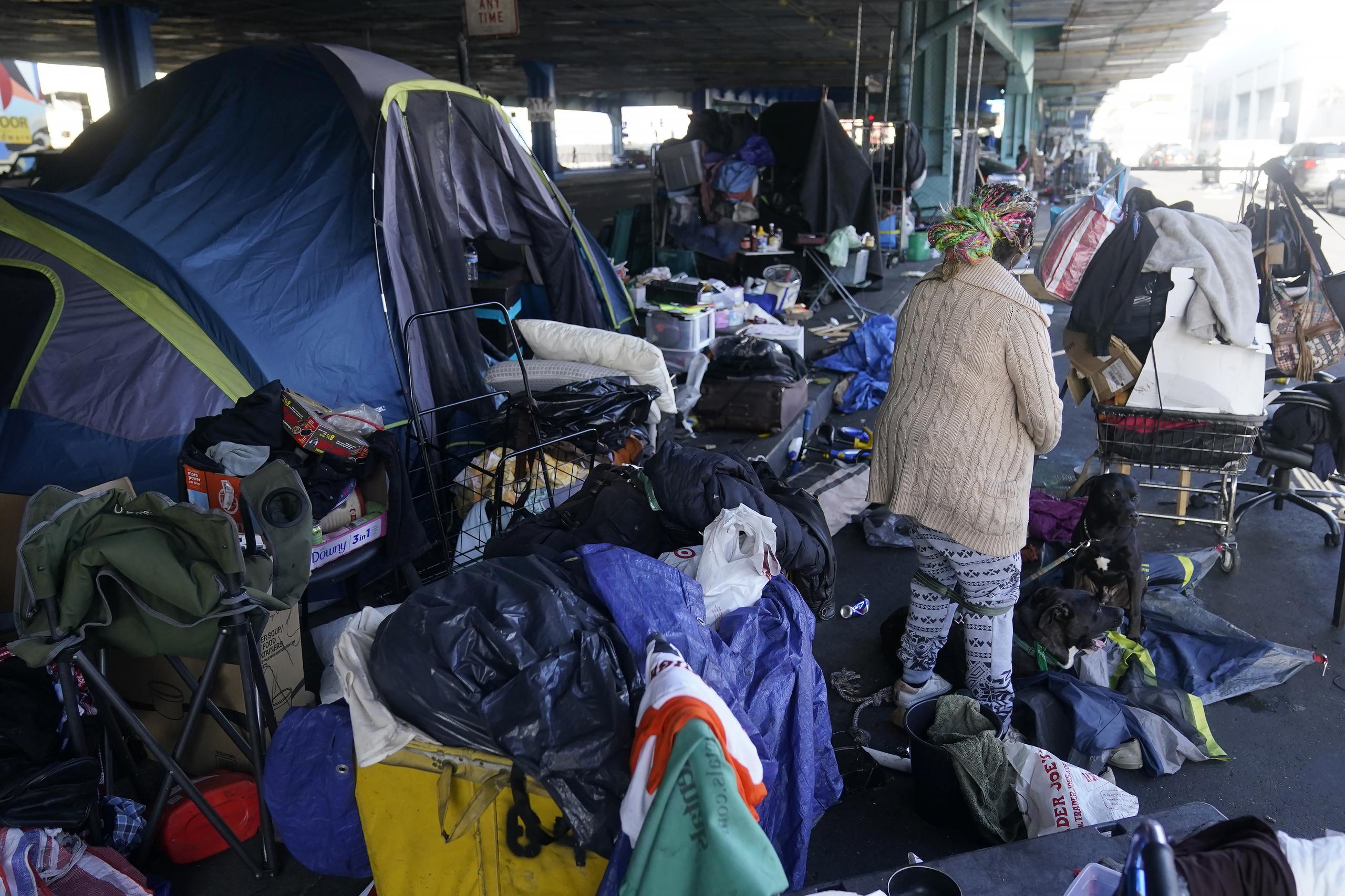 Una mujer recoge sus pertenencias antes de las tareas de retiro de un campamento de desamparados en San Francisco, el 29 de agosto de 2023. (AP Foto/Jeff Chiu, Archivo)