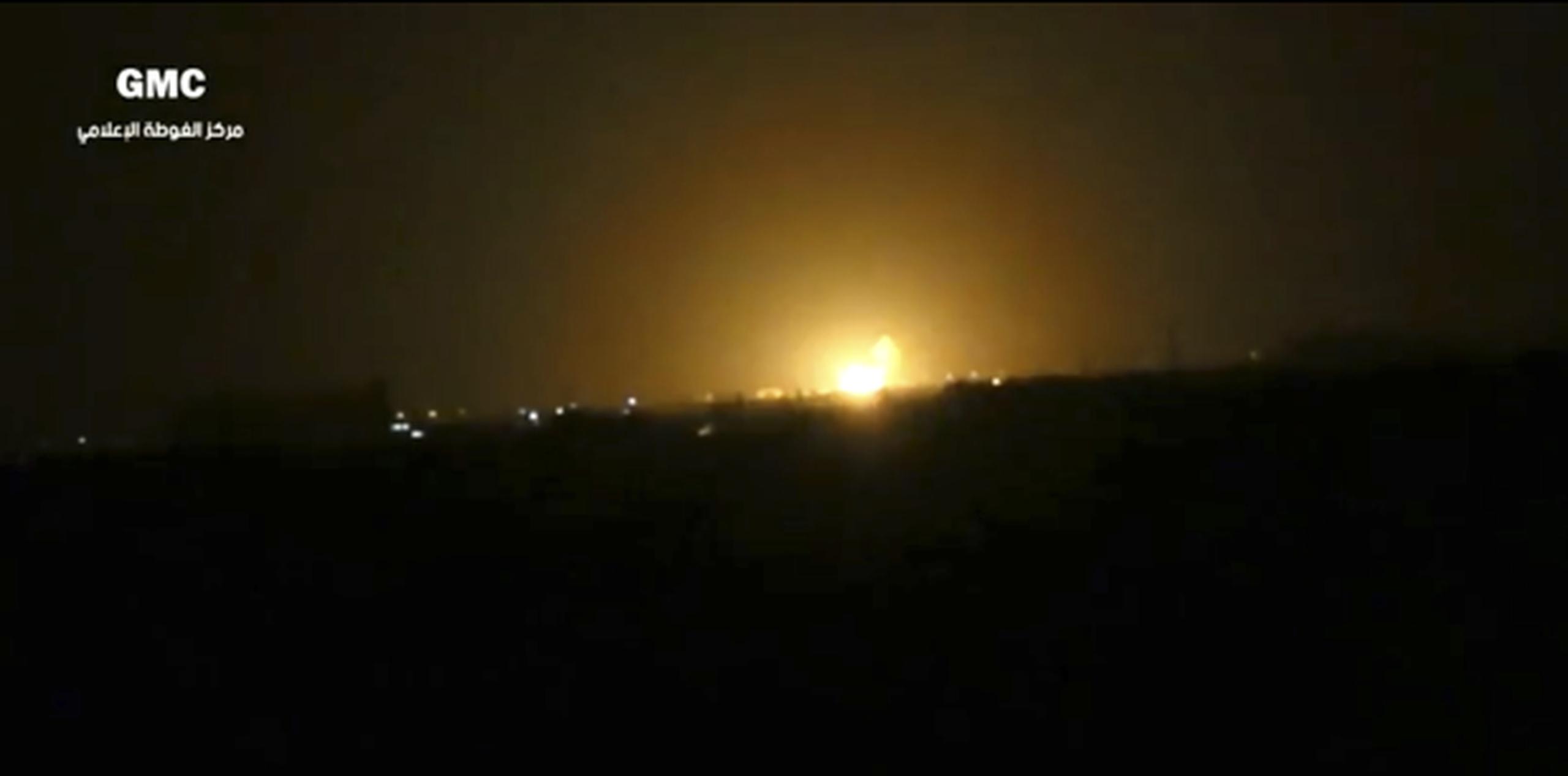 Imagen de un video cuya autenticidad fue corroborada y que muestra la explosión tras el ataque contra la instalación militar cerca del aeropuerto de Damasco. (Ghouta Media Center vía AP)
