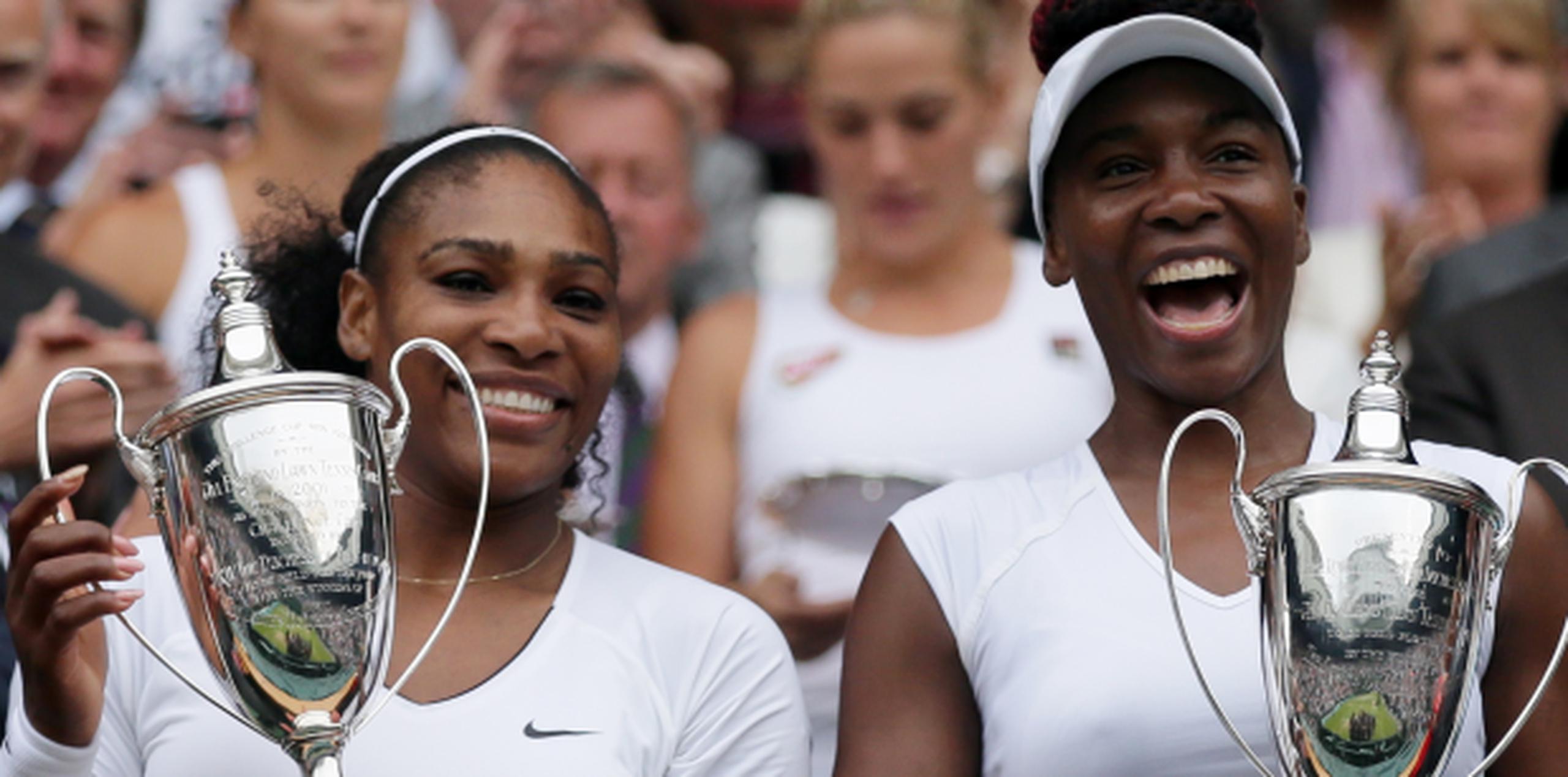 Las hermanas Serena y Venus Williams celebran su título en dobles en Wimbledon. (AP/Tim Ireland)
