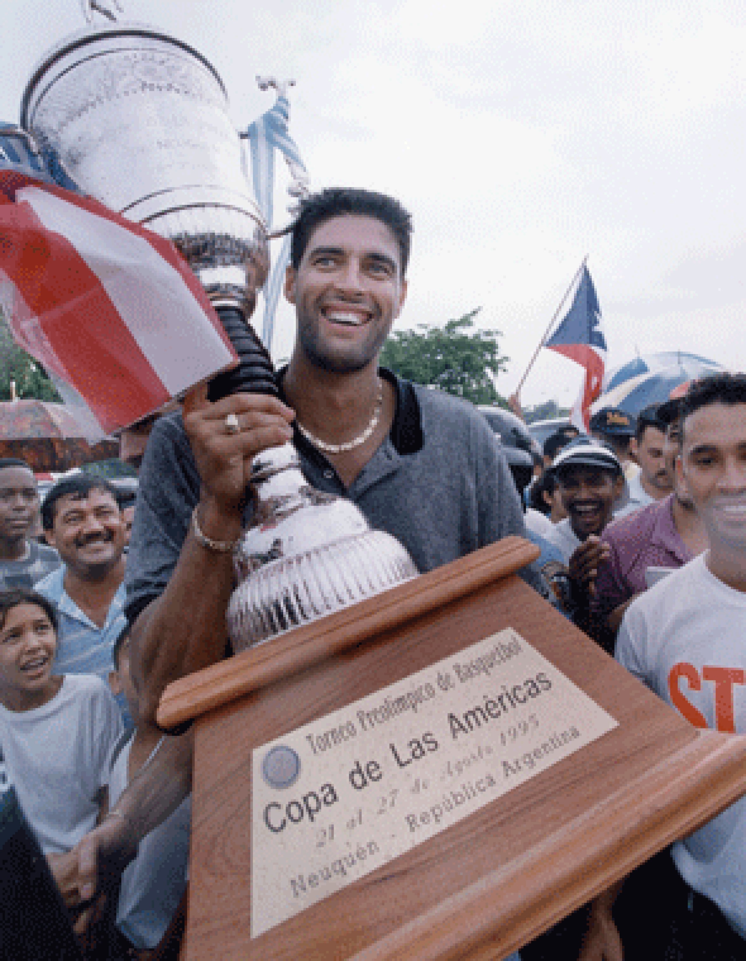 José “Piculín” Ortiz carga con el trofeo de campeón del Preolímpico de 1995 a la llegada del equipo a la Isla. (Archivo)