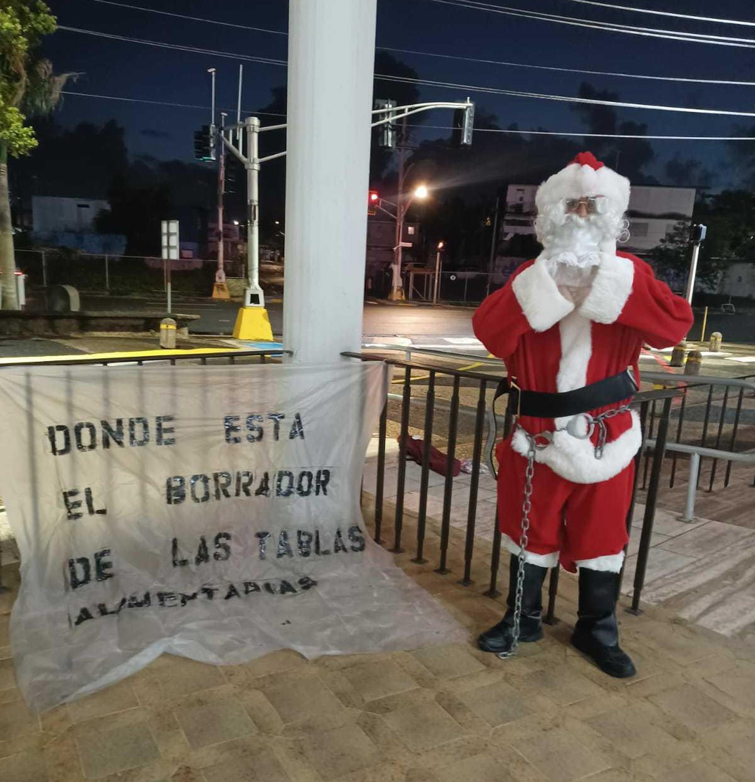 Hombre vestido de Santa Claus y encadenado exigió que se verifiquen las tablas de pensión alimentaria el 13 de diciembre de 2021 en San Juan.