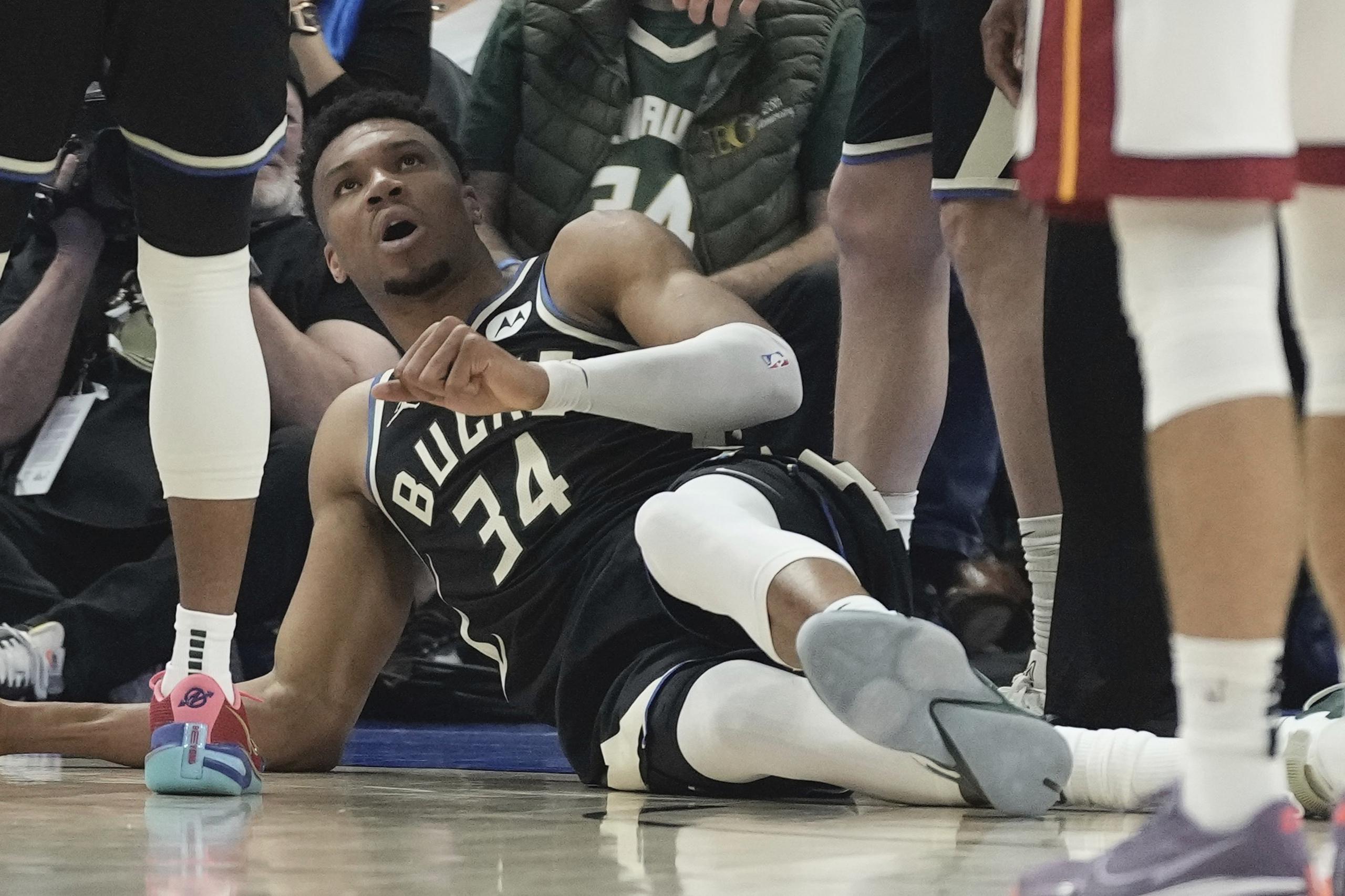 Giannis Antetokounmpo, de los Bucks de Milwaukee, yace sobre la duela después de sufrir una lesión durante la primera mitad del Juego 1 de la serie de playoffs de primera ronda del baloncesto de la NBA, el domingo 16 de abril de 2023, en Milwaukee. (AP Foto/Morry Gash)