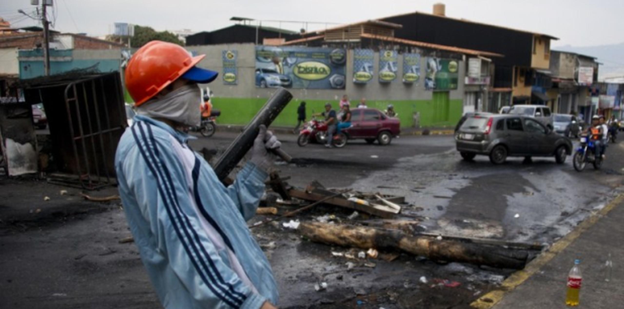Un manifestante sujeta un lanzador explosivo confeccionado a mano en San Cristóbal. (AFP)
