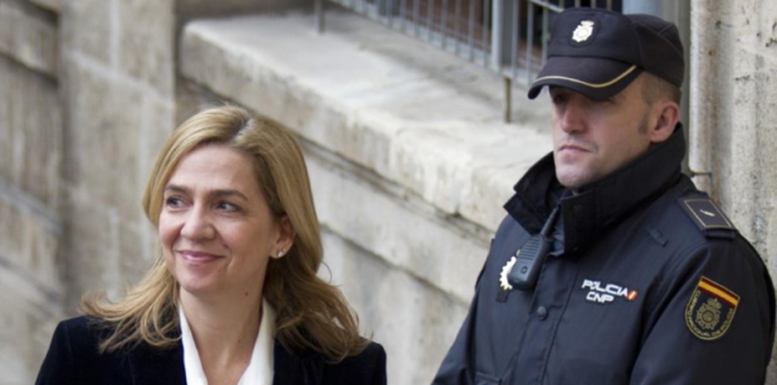La infanta Cristina, aquí ante un policía a su llegada a un tribunal en Palma de Mallorca, ha reiterado su inocencia. (AFP)